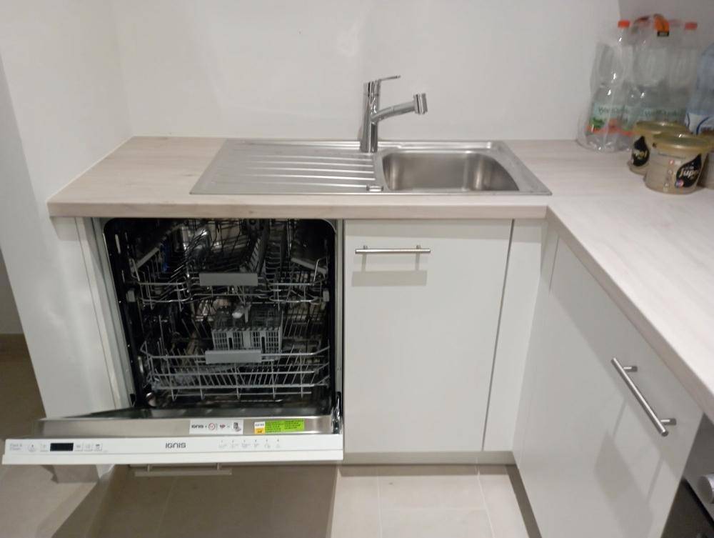 Moderne Einbauküche mit integriertem Geschirrspüler und Spülbecken.