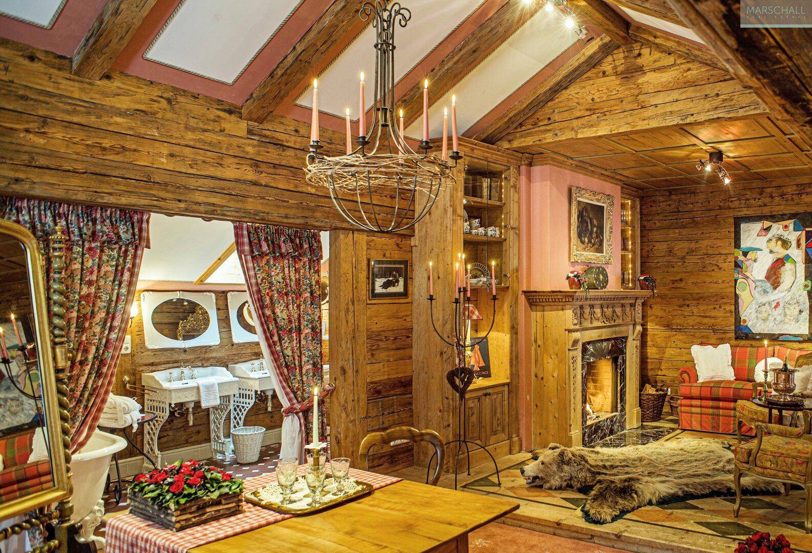 Rustikales Wohnzimmer mit Holzbalken, Kamin und traditioneller Einrichtung, strahlt Gemütlichkeit aus.