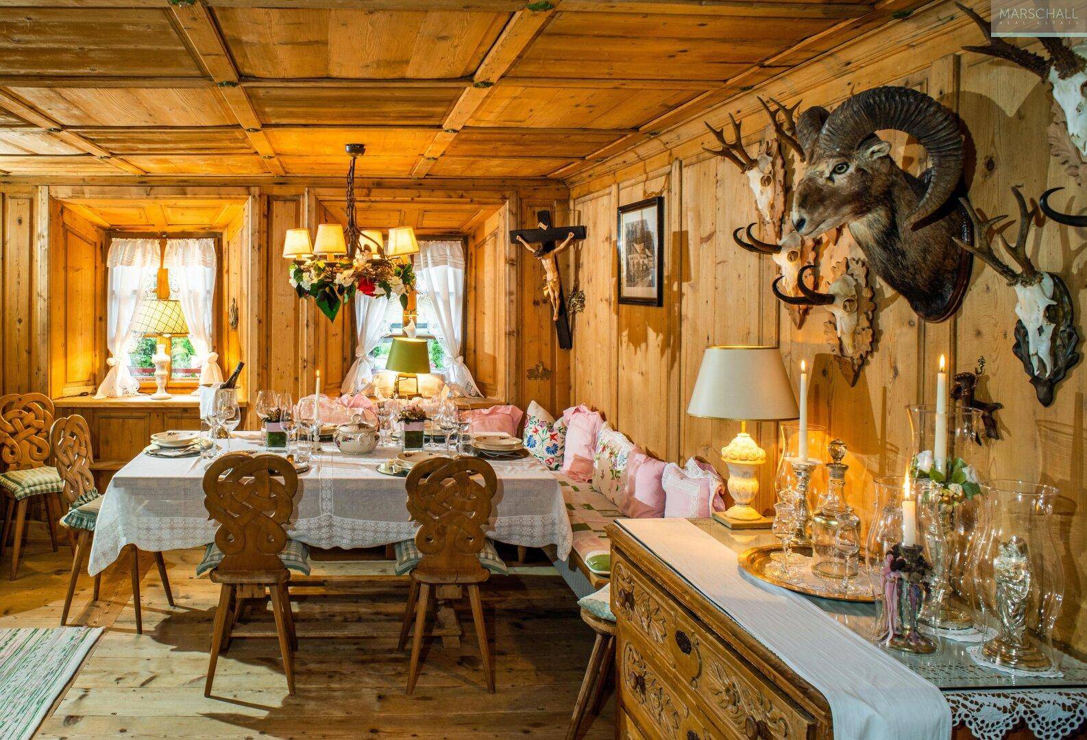 Traditioneller Essbereich mit Holzvertäfelung, Jagdtrophäen und einem großen Esstisch für viele Gäste.