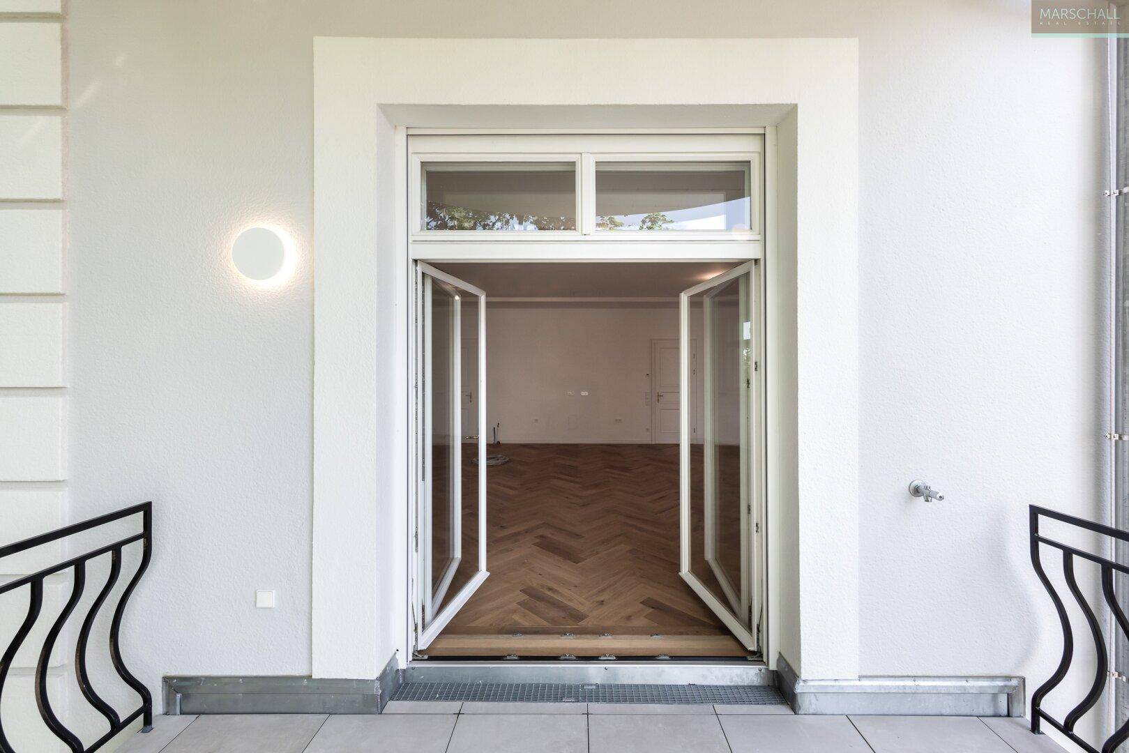 Zugang zu einem Balkon mit großen Glastüren, die viel Licht in den Innenraum lassen.