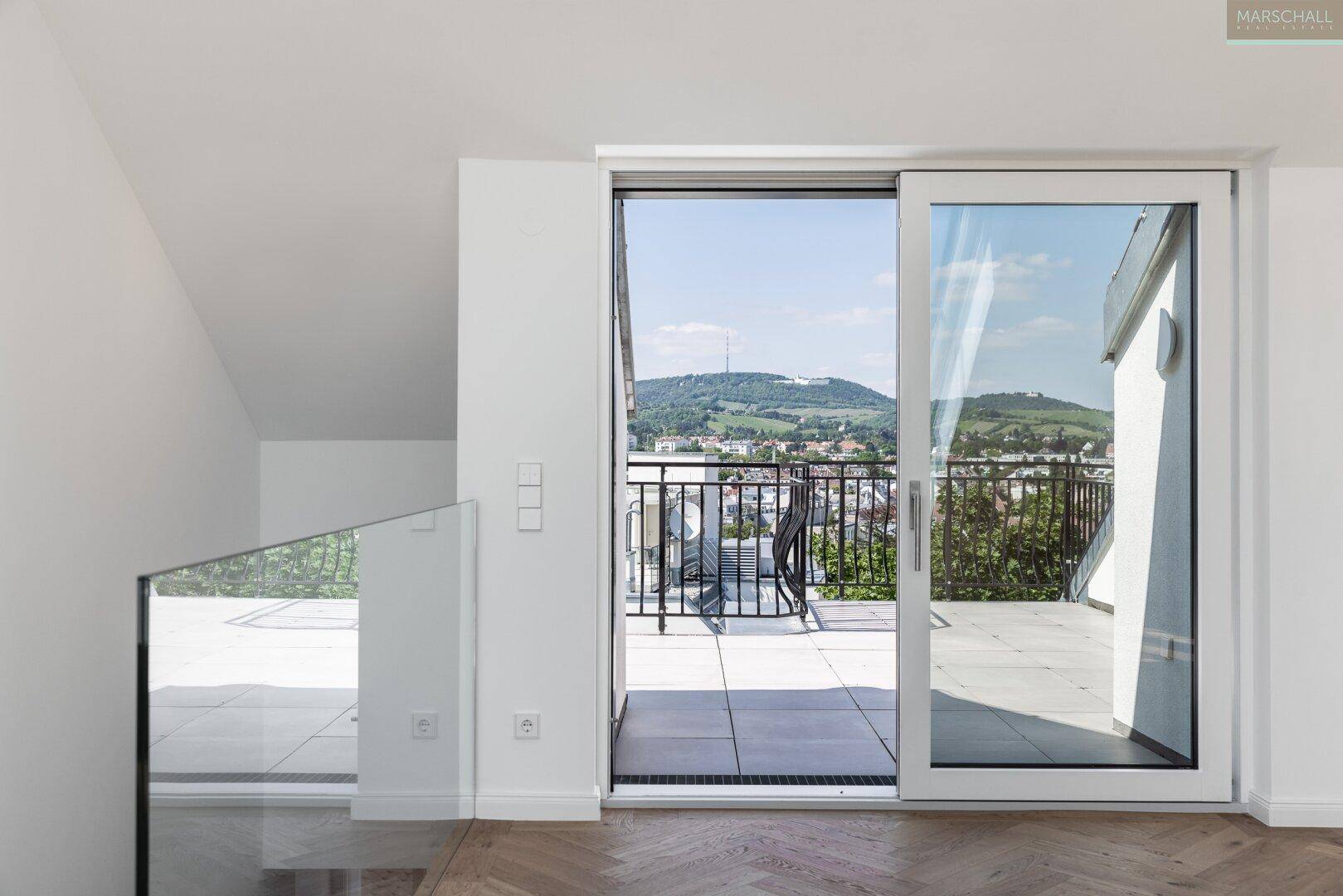 Geräumiger Balkon mit Panoramablick auf die grüne Hügellandschaft und die Umgebung.
