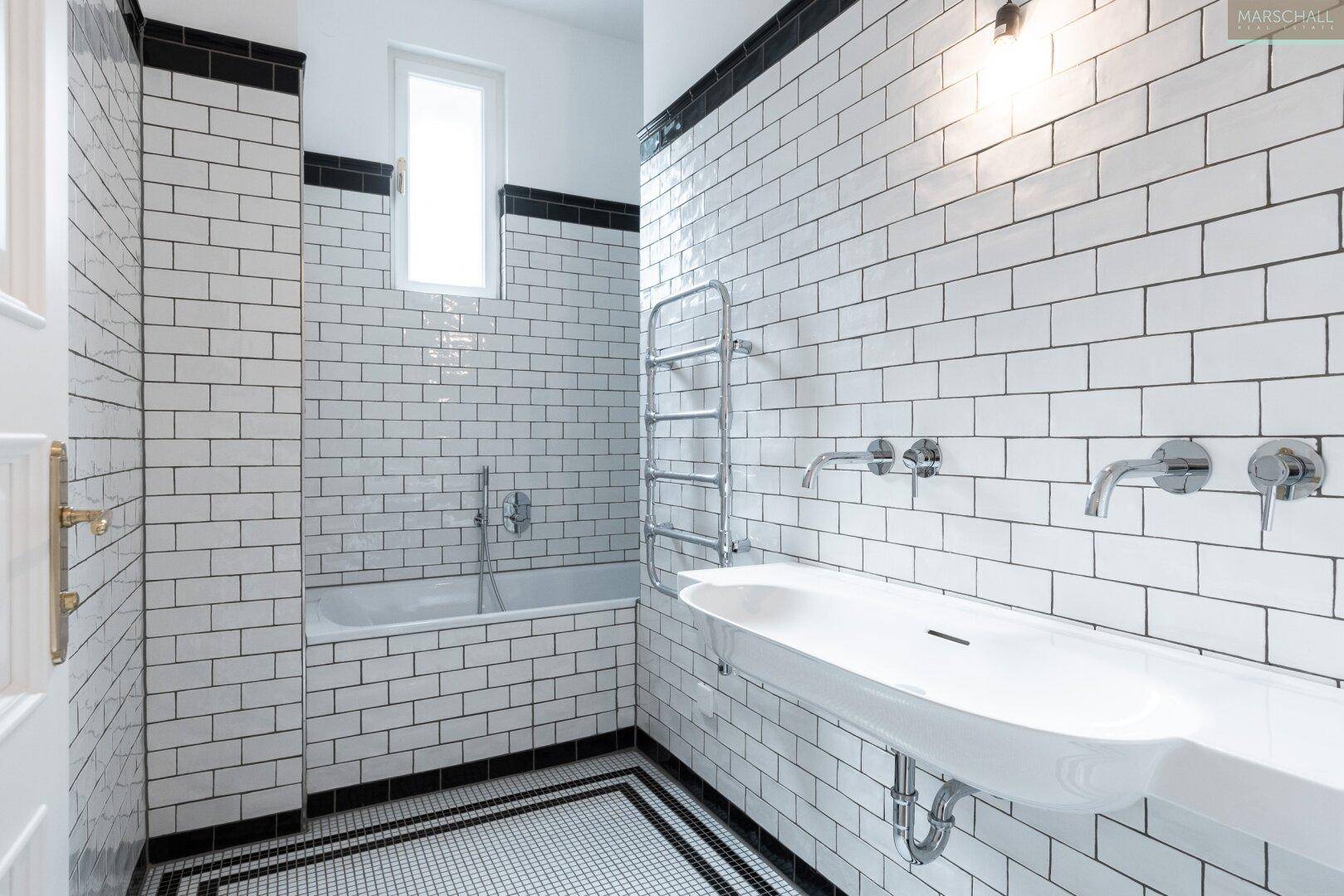 Modernes Badezimmer mit U-Bahn-Fliesen, Badewanne und beheiztem Handtuchhalter.