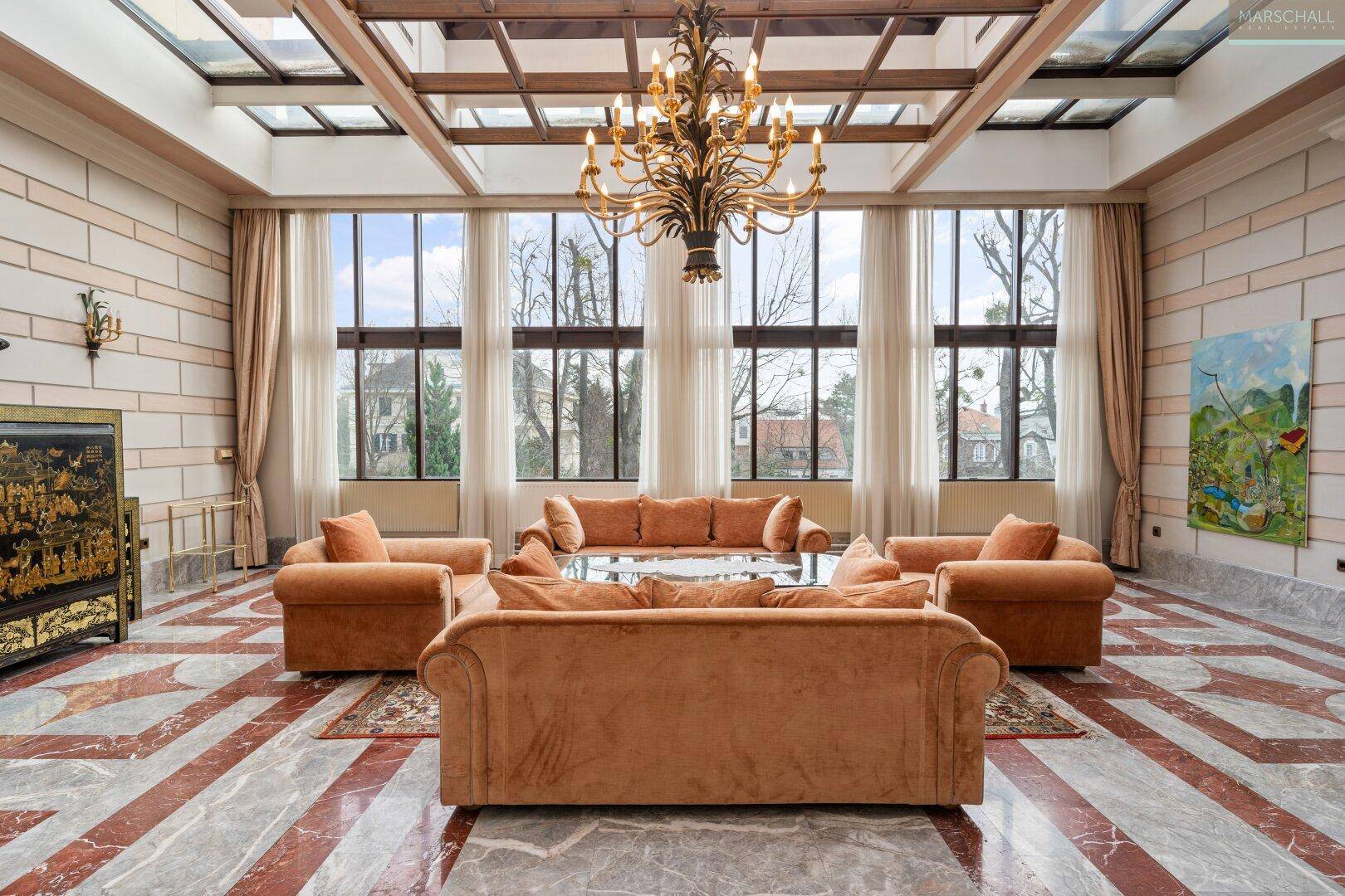 Heller Wohnbereich mit Glasdach, großen Fenstern und bequemen Sofas, ideal für gesellige Runden.