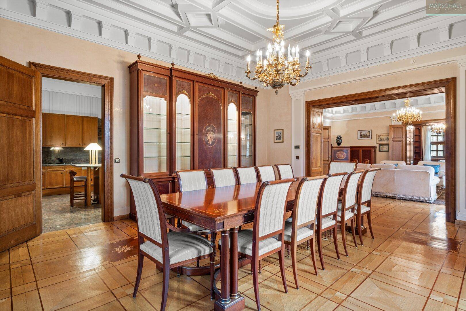 Klassischer Essbereich mit großem Holztisch, Vitrinenschrank und Zugang zur Küche.