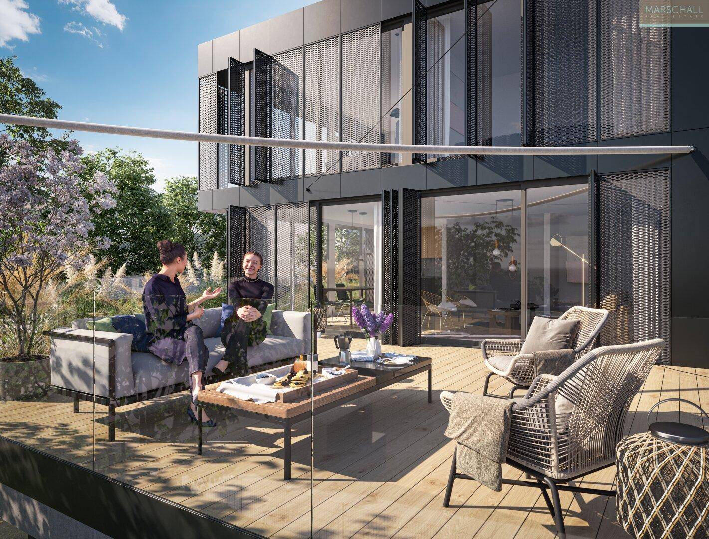 Geräumige Holzterrasse mit bequemen Lounge-Möbeln und Blick ins Grüne, ideal zum Entspannen.