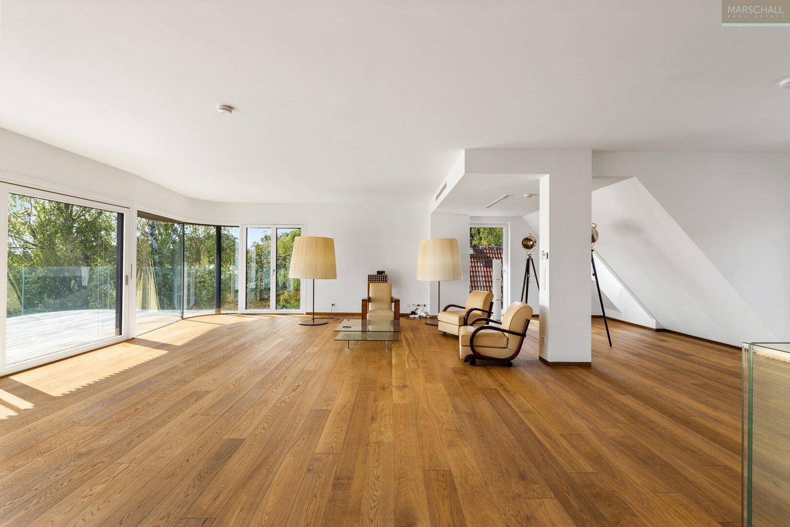 Helles, geräumiges Wohnzimmer mit Eichenparkett, großen Glasfronten und Zugang zur Terrasse.