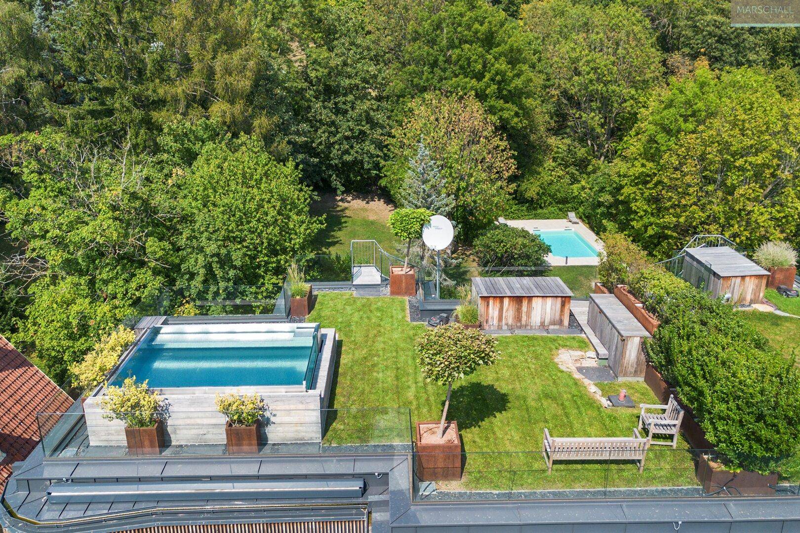 Luftaufnahme eines luxuriösen Anwesens mit mehreren Pools, gepflegten Gärten und Terrassenbereichen.