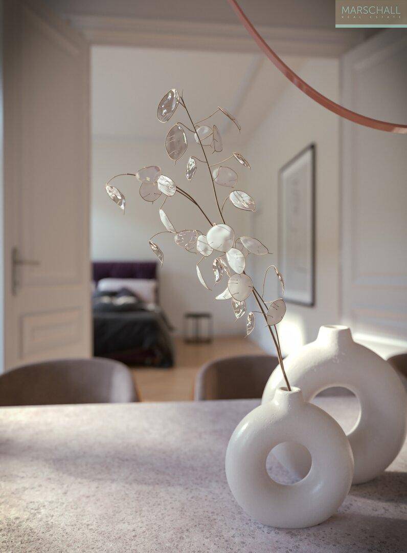 Detailaufnahme des Esstisches mit minimalistischer Dekoration und Blick in ein angrenzendes Schlafzimmer.