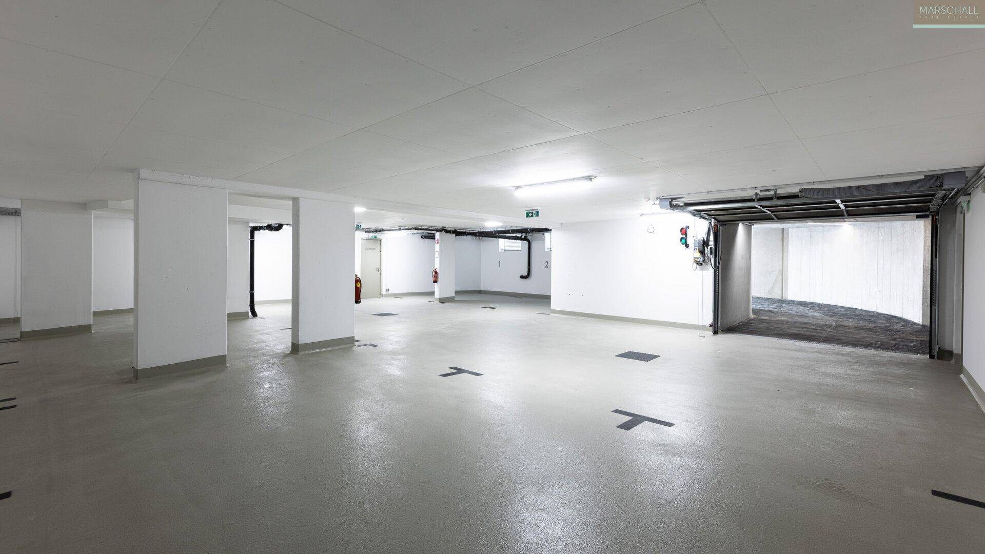 Geräumige Tiefgarage mit mehreren Stellplätzen und direktem Zugang zum Gebäude.