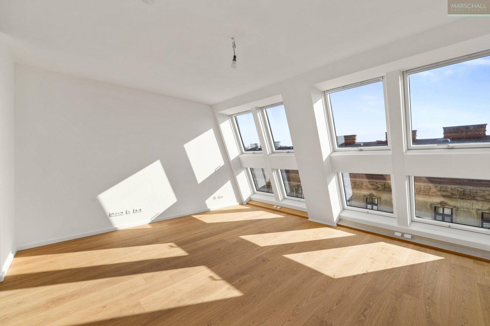 Heller Wohnraum mit großen Dachfenstern, Holzboden und viel natürlichem Licht.