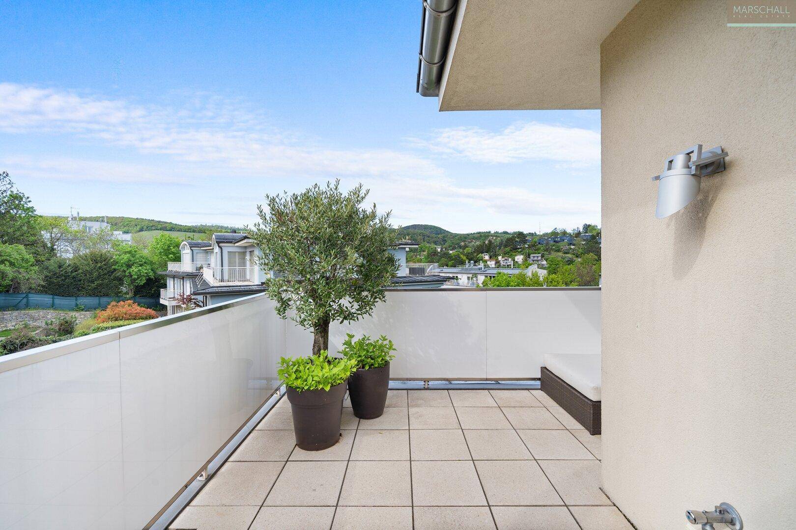 Kleiner Balkon mit Fliesenboden und einer Topfpflanze, bietet einen ruhigen Außenbereich.