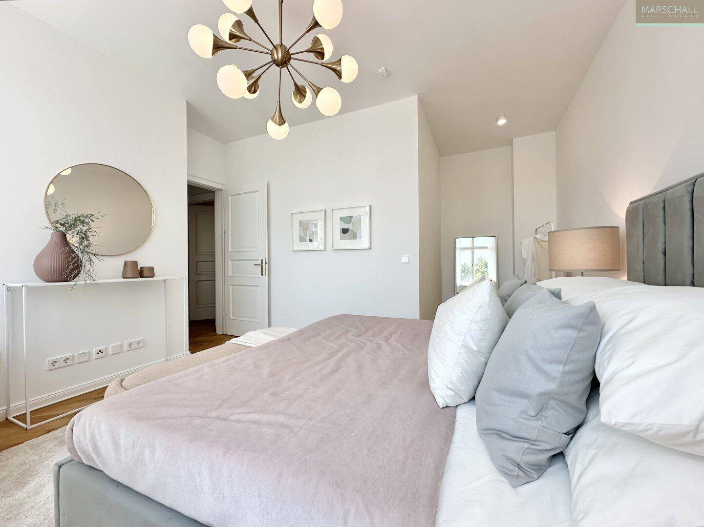 Modernes Schlafzimmer mit großem Bett, stilvoller Beleuchtung und minimalistischer Dekoration.