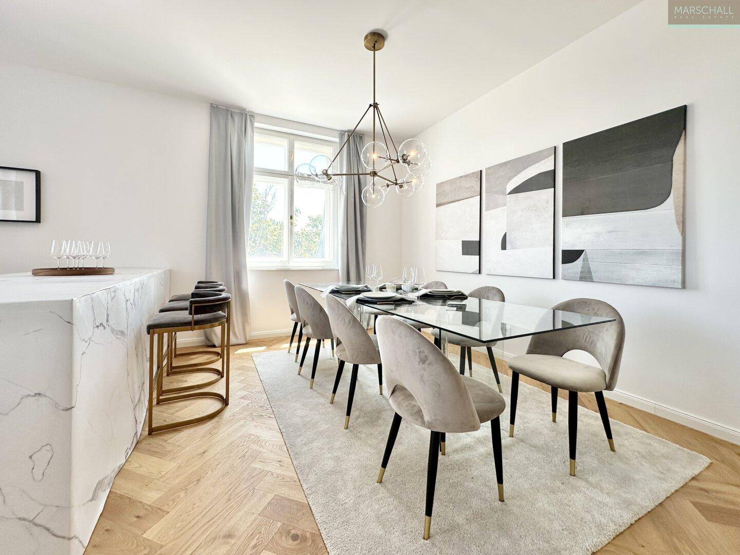 Eleganter Essbereich mit großem Glastisch, Samtstühlen und einer modernen Bar mit Marmoroptik.