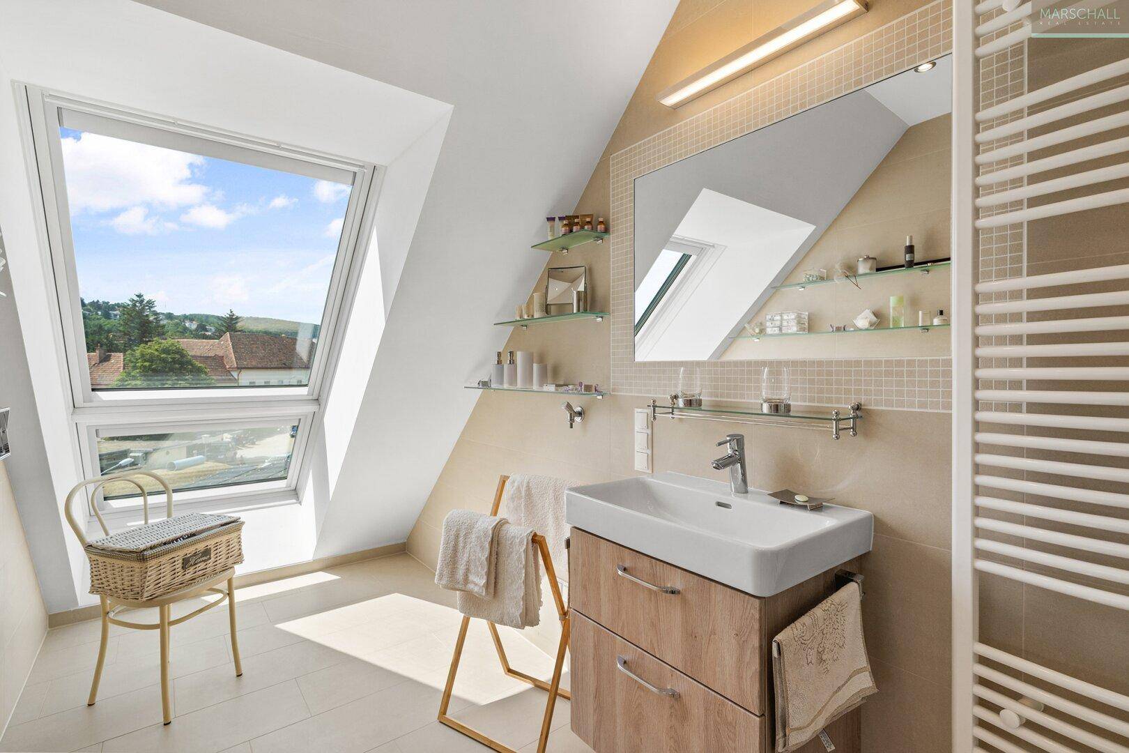 Modernes Badezimmer mit Dachfenster, Waschtisch und beheiztem Handtuchhalter.