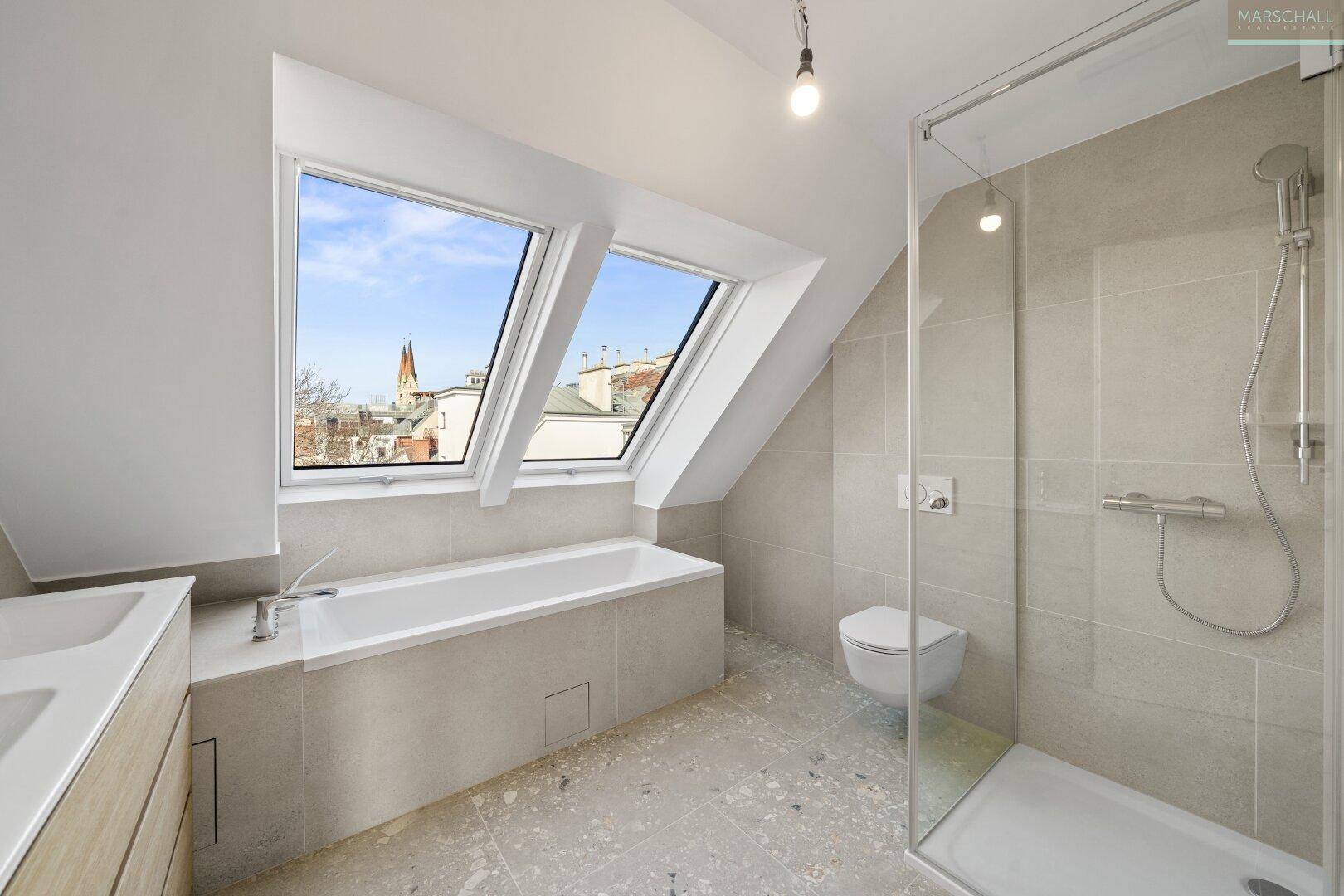 Modernes Badezimmer mit Badewanne, Dusche, Dachfenstern und hellen Fliesen, sehr gepflegt.