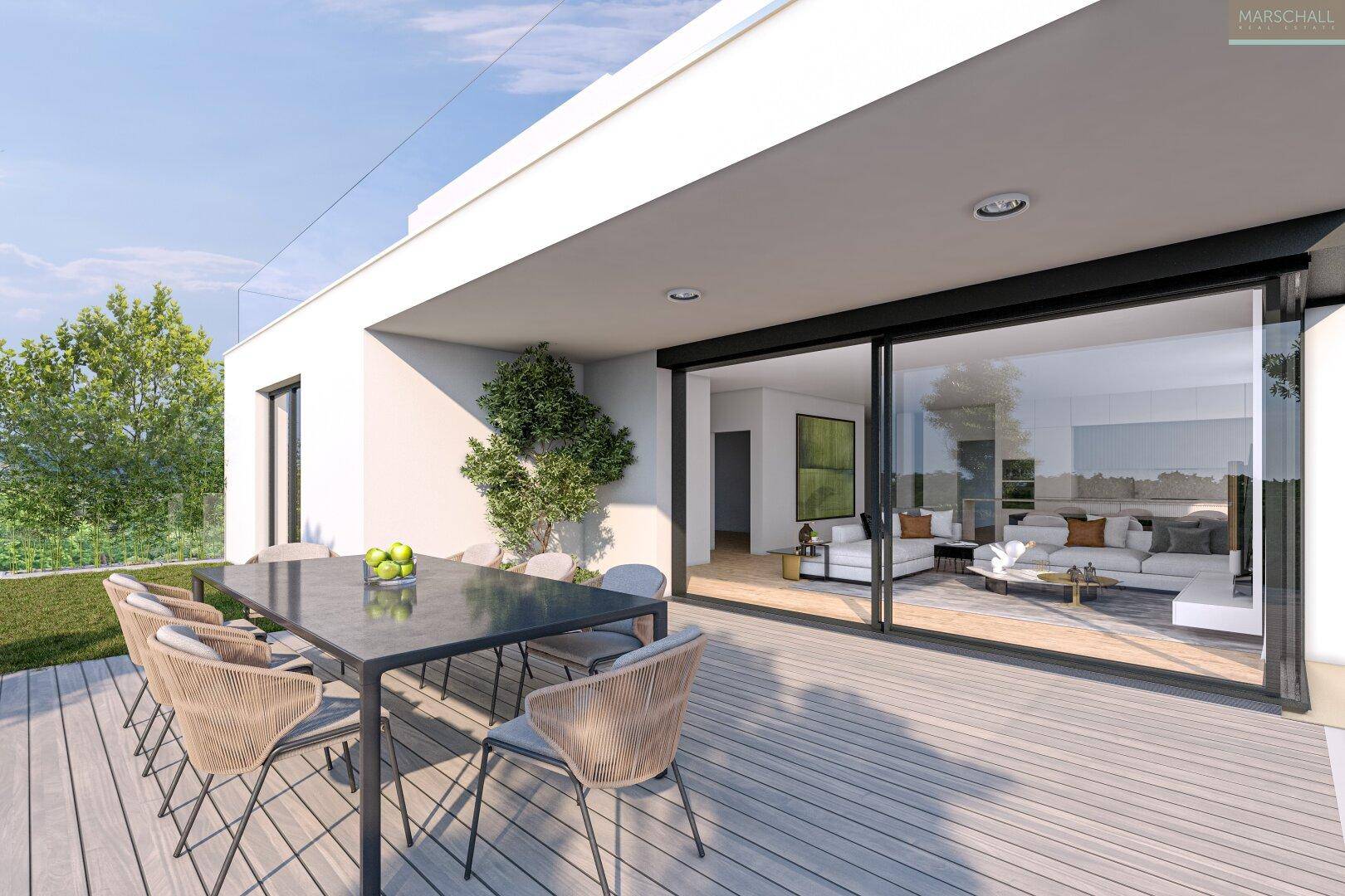 Großzügige Holzterrasse mit Esstisch und Zugang zum Wohnbereich, umgeben von Grün.