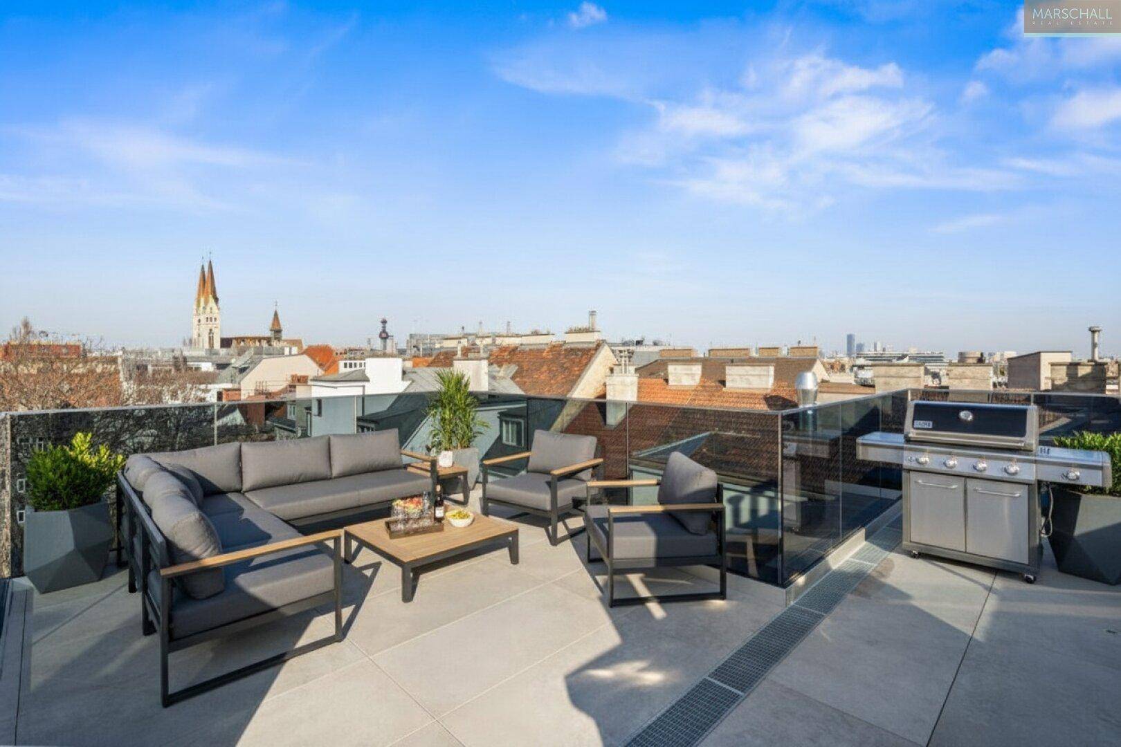 Großzügige Dachterrasse mit Lounge-Möbeln, Grillbereich und Stadtblick, ideal zum Entspannen.