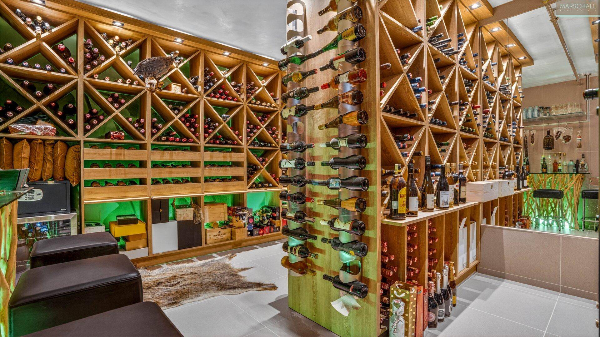 Gut ausgestatteter Weinkeller mit vielen Holzregalen, gefüllt mit einer umfangreichen Weinsammlung.
