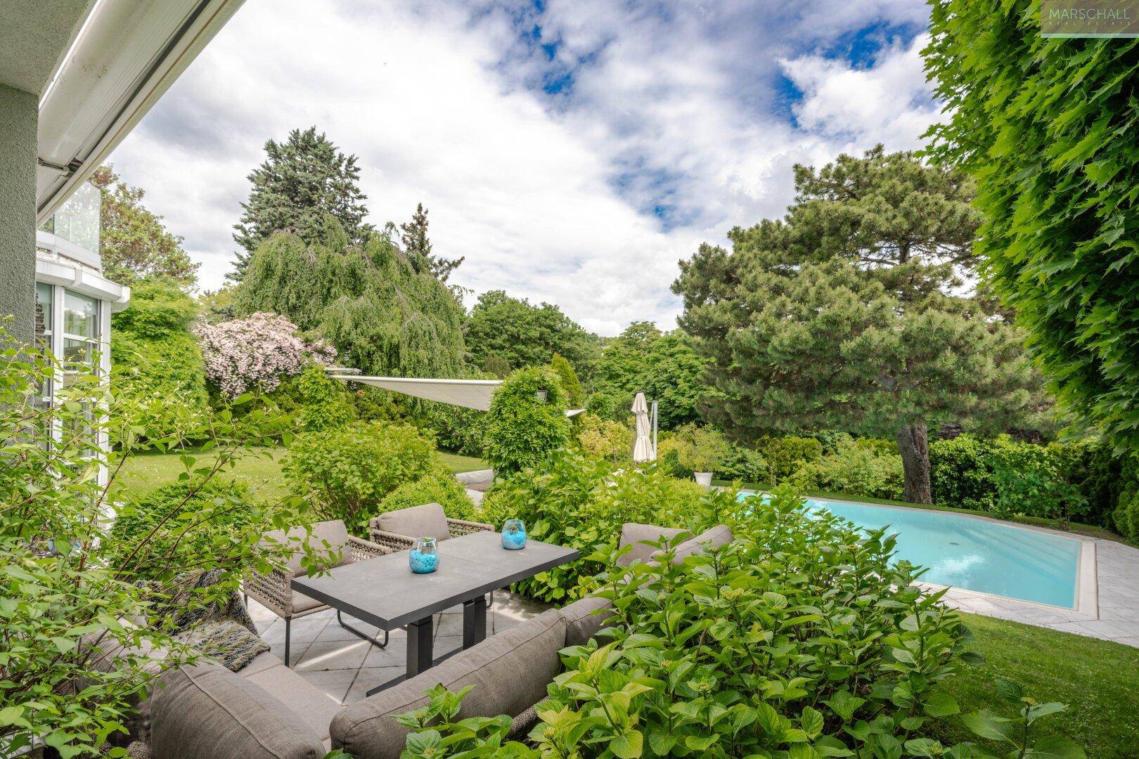 Entspannter Terrassenbereich mit bequemen Sitzmöbeln und einem schönen Blick auf den Pool und Garten.