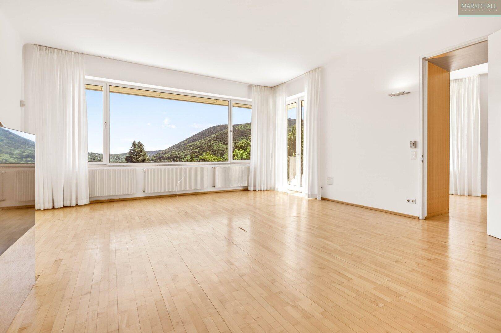 Geräumiges Schlafzimmer mit Holzboden und weitem Blick auf die Landschaft.