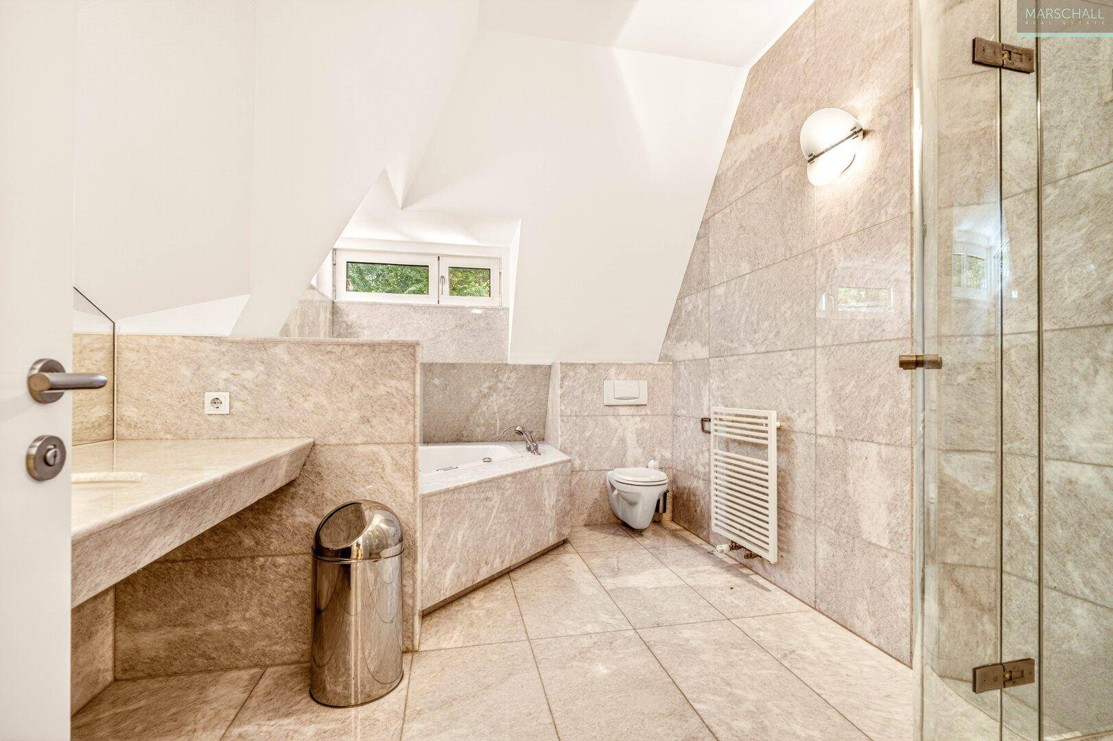 Modernes Badezimmer mit hellen Fliesen, Eckbadewanne und separater Dusche.