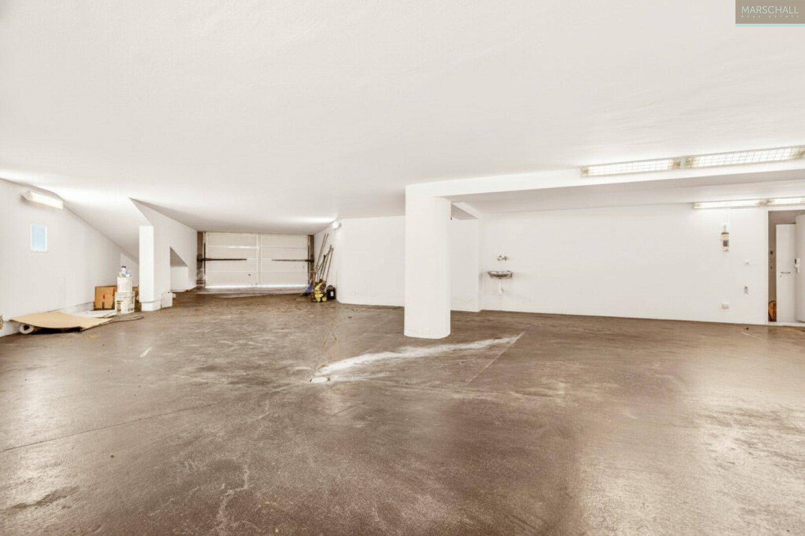 Geräumige Garage mit Betonboden und ausreichend Platz für mehrere Fahrzeuge.