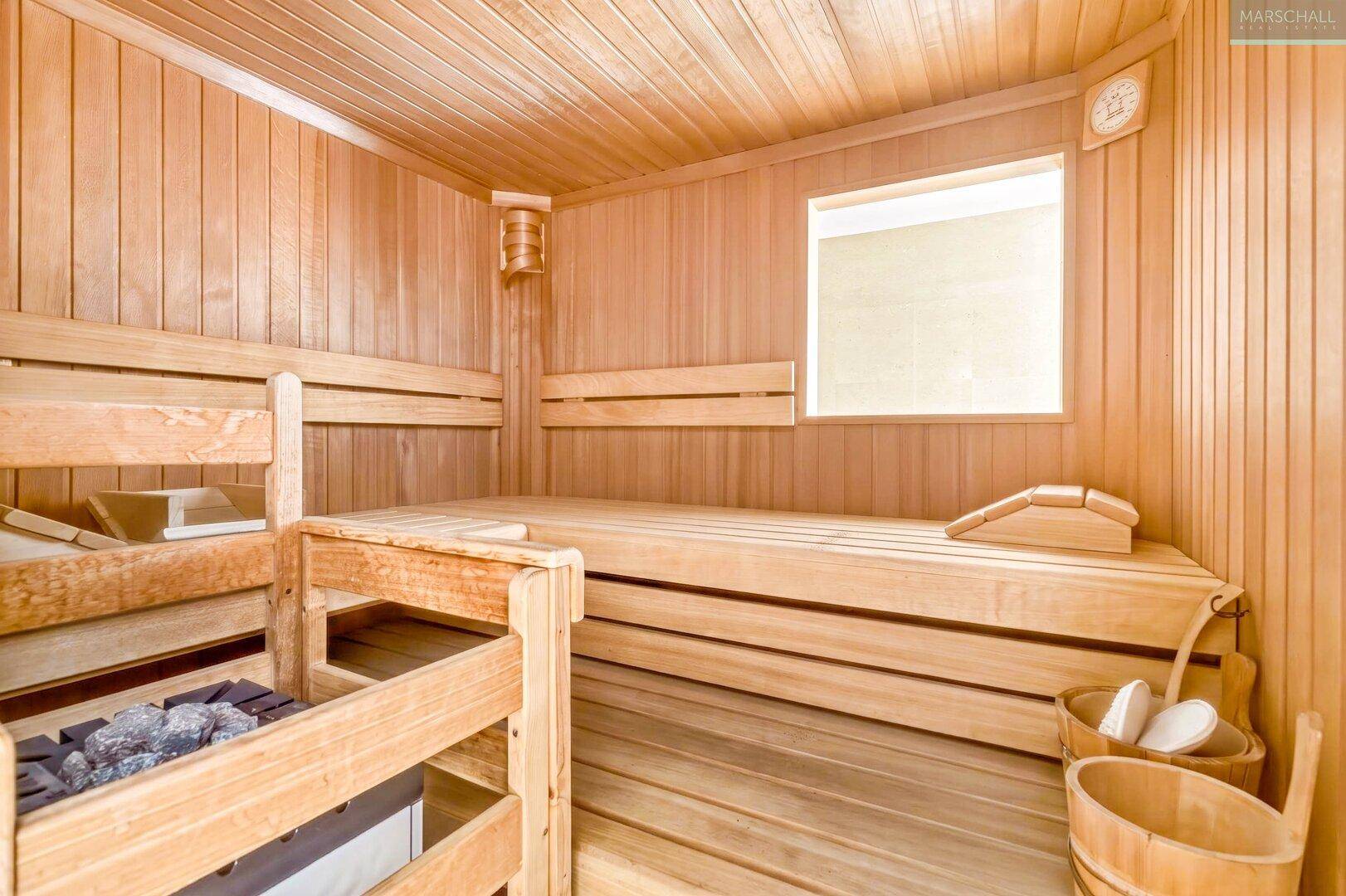Gemütliche Holzsauna mit Bänken und Saunaofen für entspannende Momente.