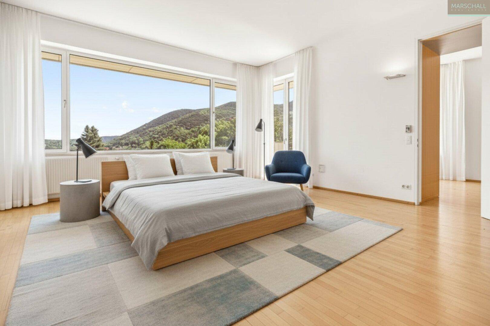 Helles Schlafzimmer mit Holzboden, großem Fenster und Bergblick.