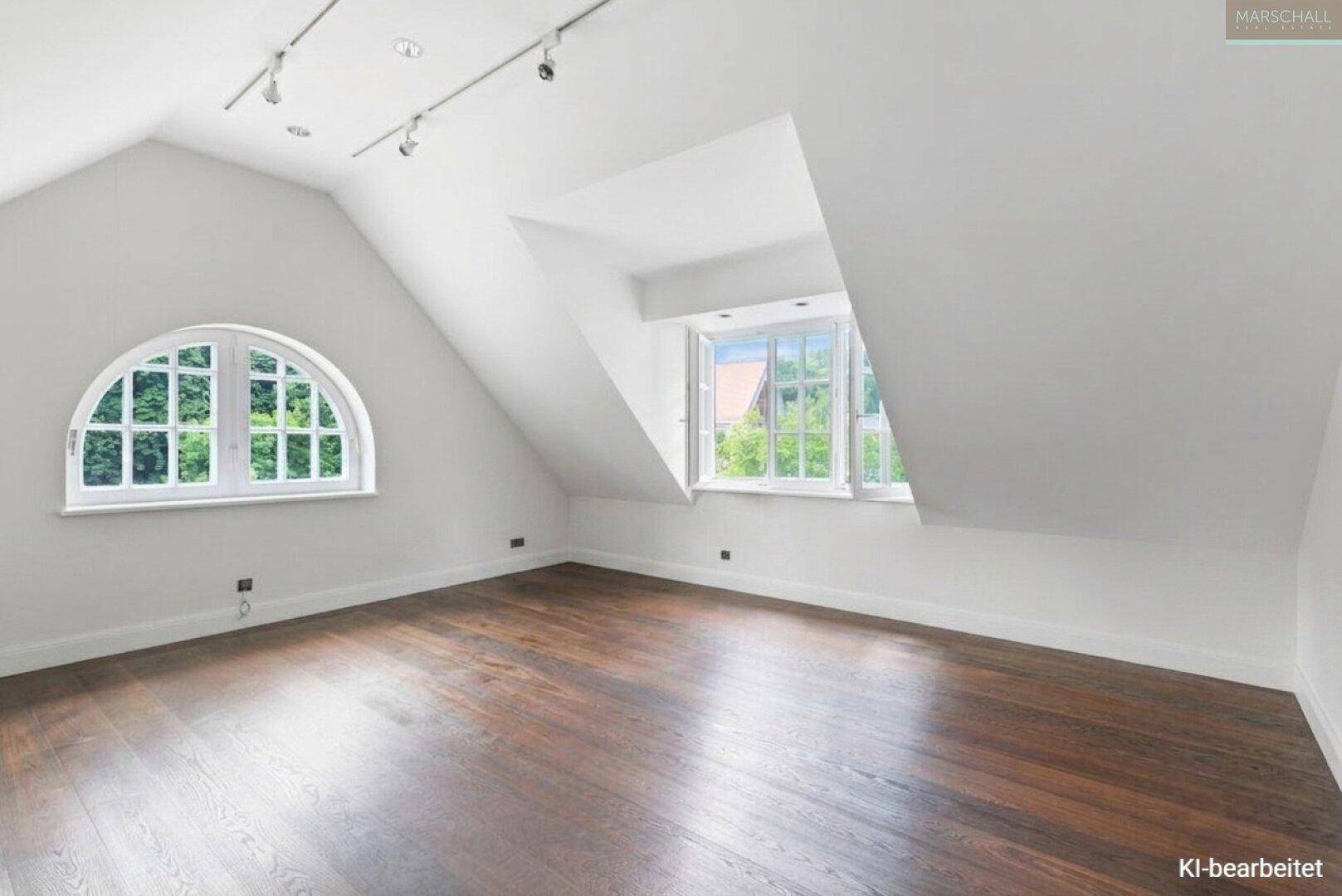 Helles Dachgeschosszimmer mit dunklem Holzboden, Rundbogenfenster und Gaubenfenster.