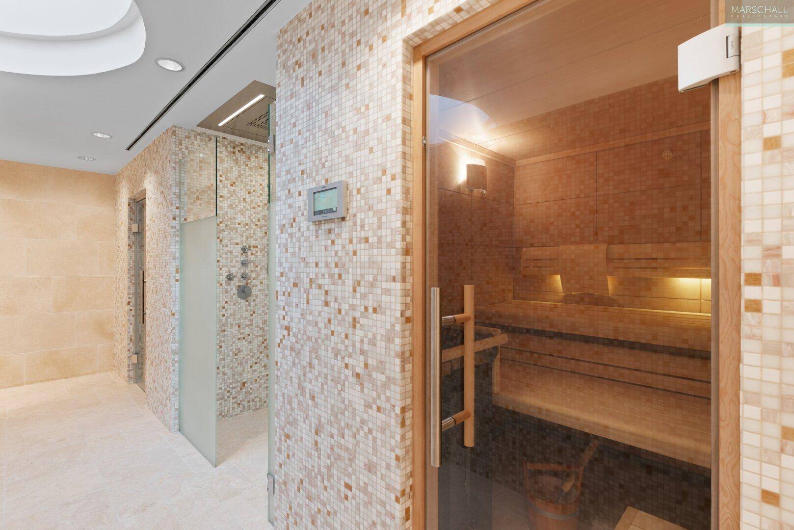 Eingang zur Sauna und Duschen im luxuriösen Wellnessbereich mit Mosaikfliesen.