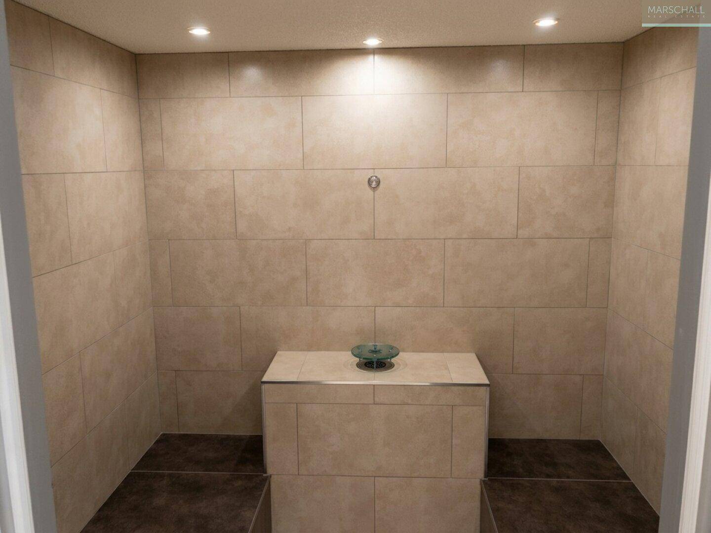 Gefliester Raum mit Sitzgelegenheiten, ideal als Dampfbad oder Teil eines Wellnessbereichs.