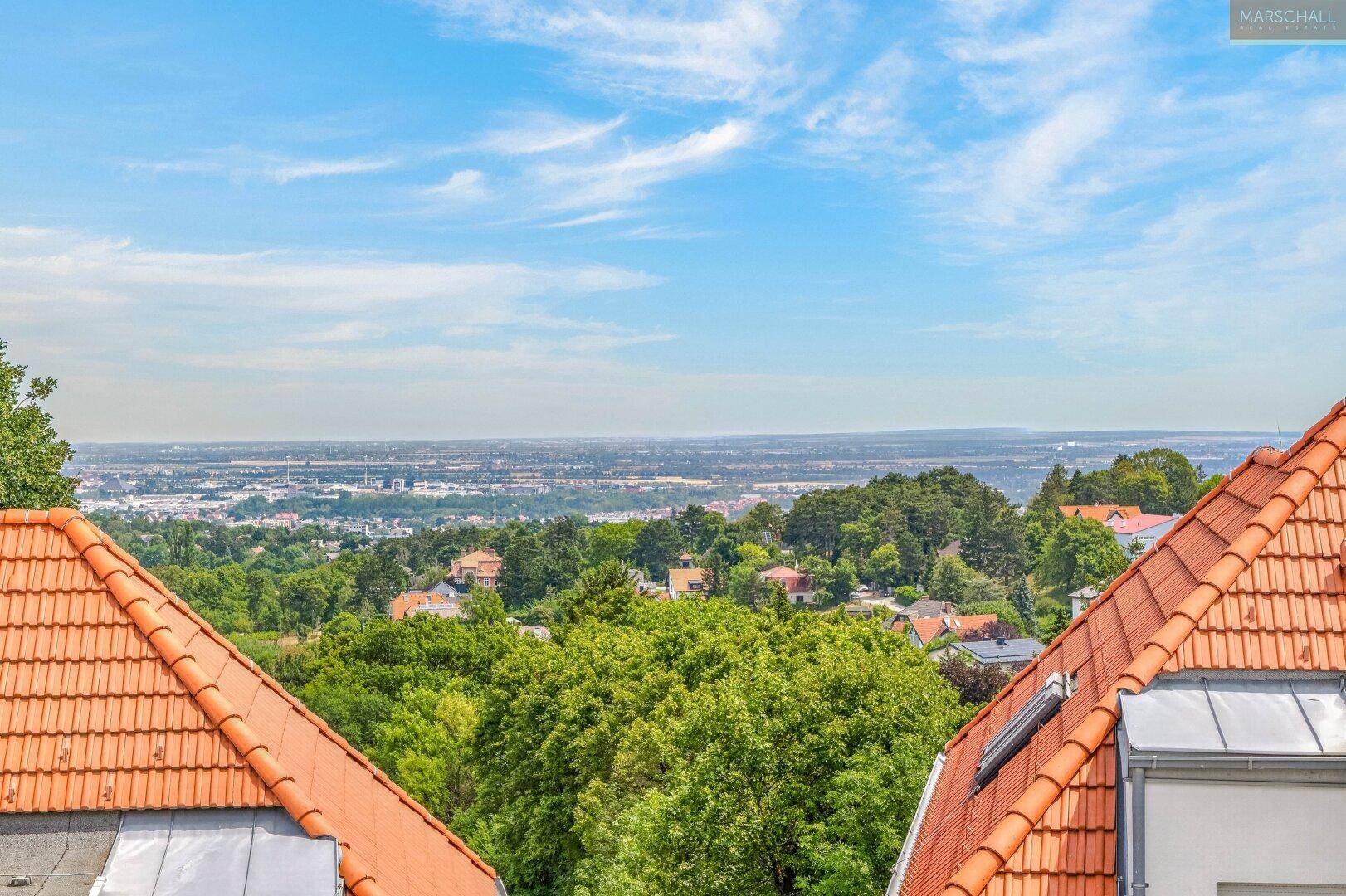 Weitläufiger Blick über die Stadt und grüne Umgebung von der Dachterrasse.