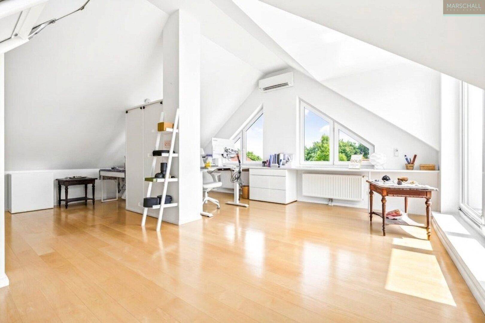 Geräumiges Dachgeschoss mit Holzboden, schrägen Wänden und viel Tageslicht.