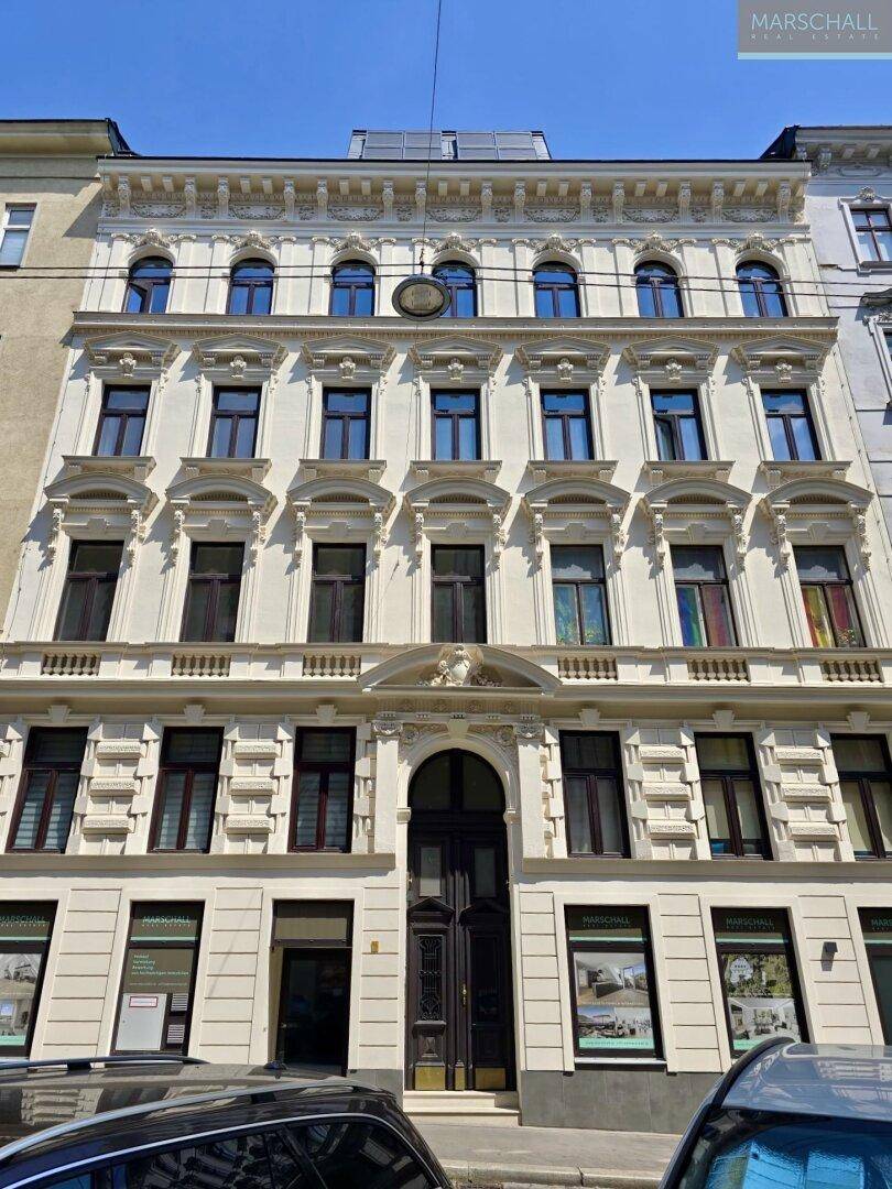 Historisches Gebäude mit reich verzierter Fassade und vielen Fenstern in der Stadt.