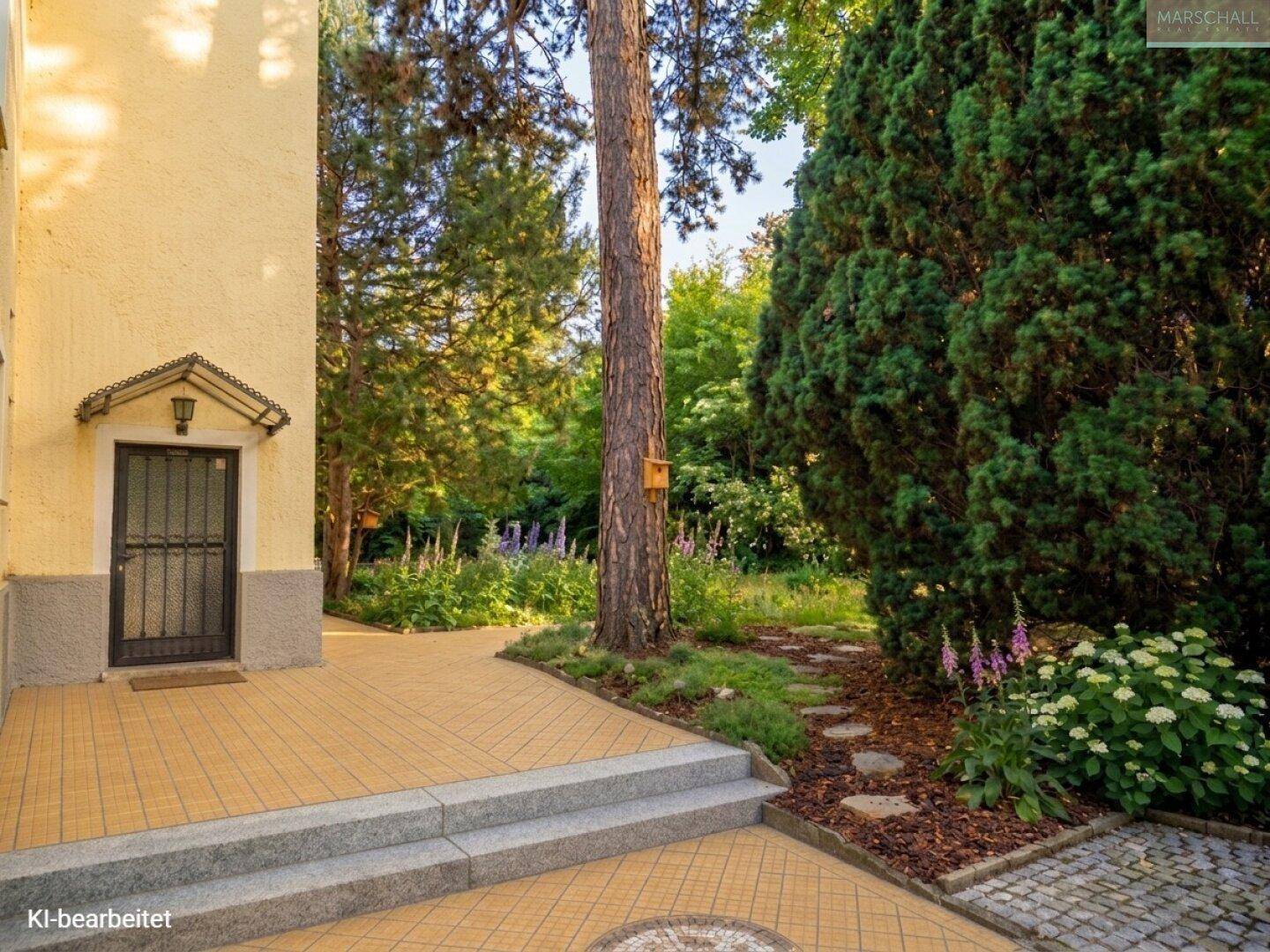 Seitlicher Eingangsbereich mit gefliestem Weg, der in den grünen Garten führt.