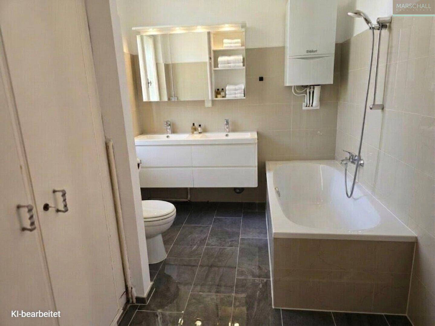Modernes Badezimmer mit Doppelwaschbecken, Badewanne und grauen Fliesen.