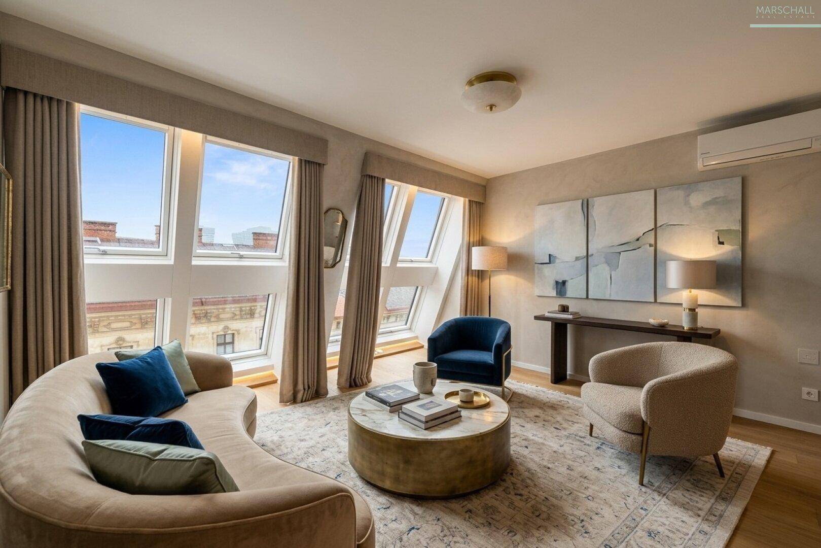 Helles Wohnzimmer mit geschwungener Couch, runden Tischen und schrägen Dachfenstern.