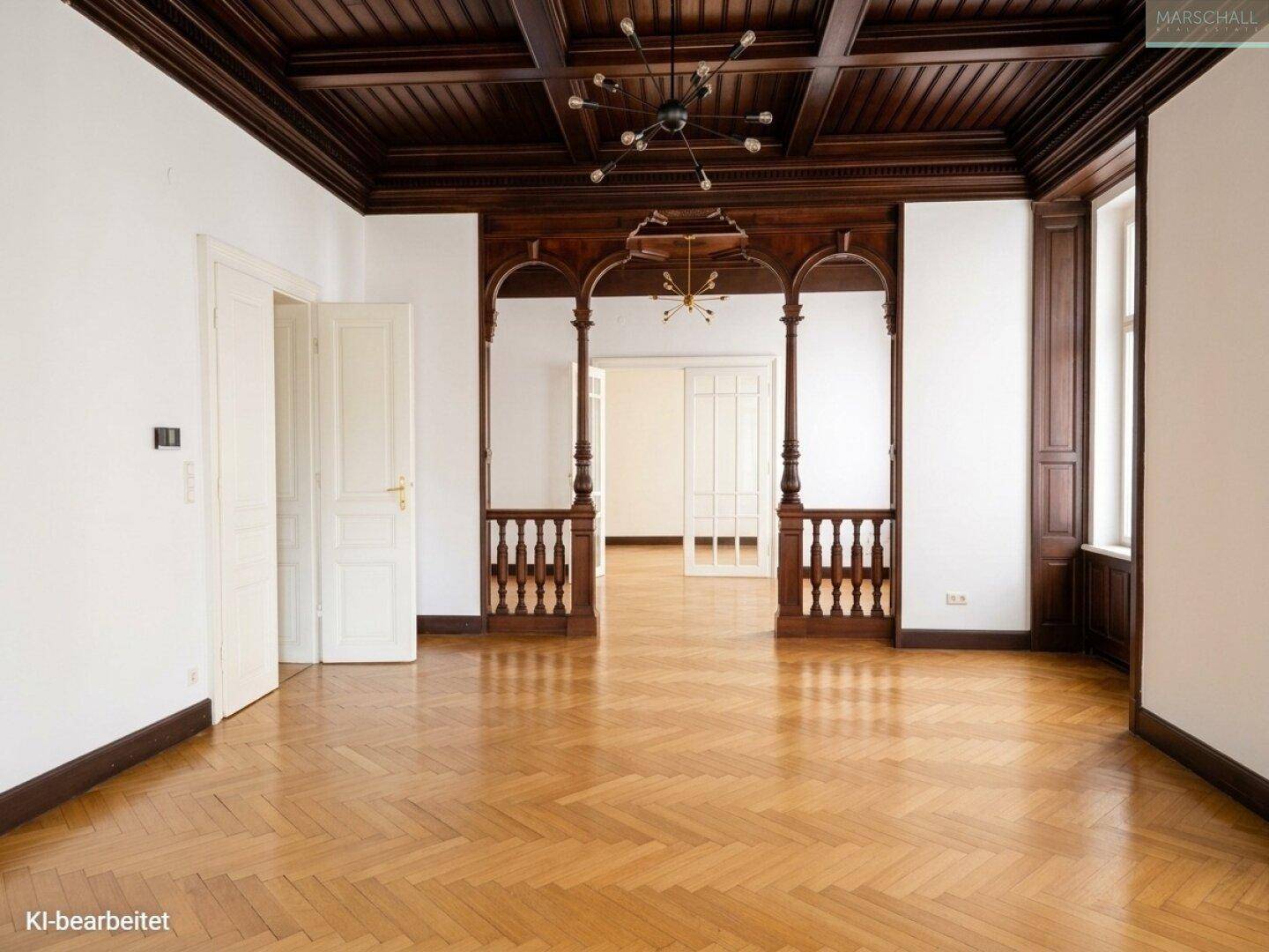 Geräumiger Wohnbereich mit aufwendiger Holzkassettendecke und klassischem Fischgrätparkett, ideal für Empfänge.