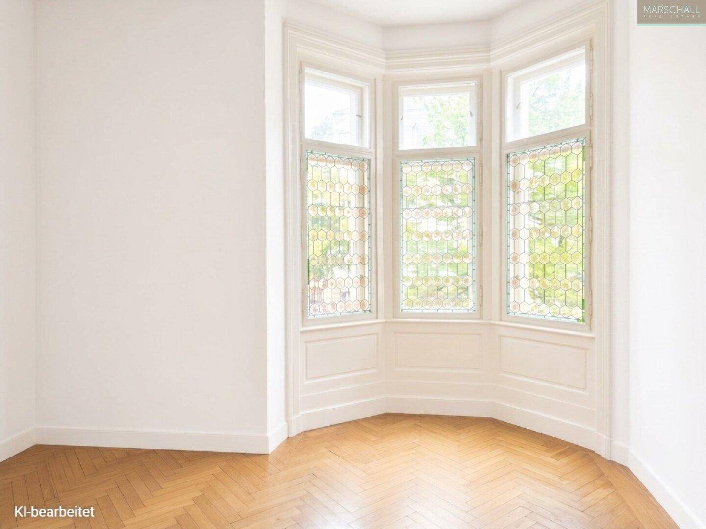 Charmante Erkerzone mit dekorativen Buntglasfenstern und klassischem Fischgrätparkett, ideal für eine Leseecke.