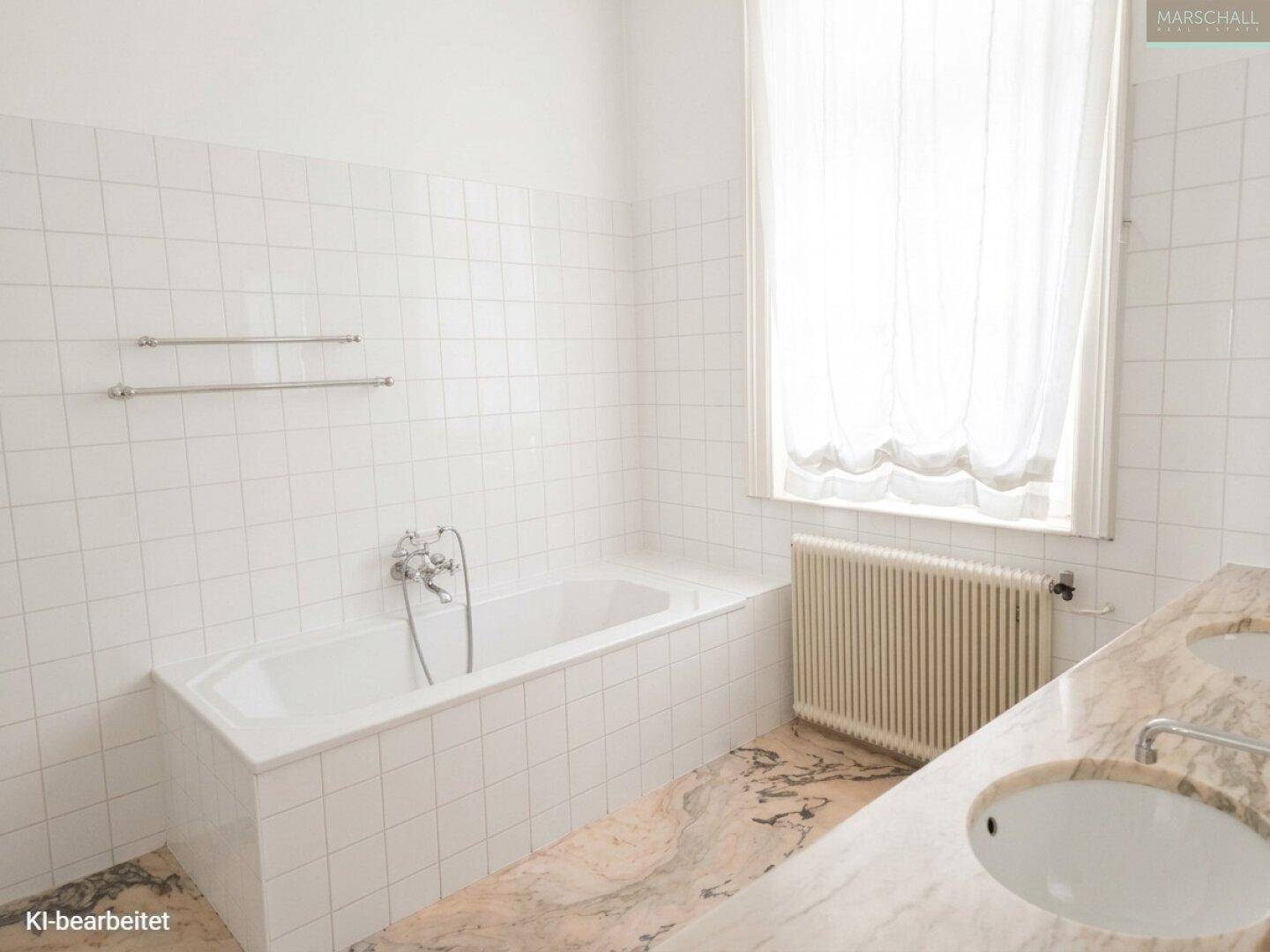 Klassisches Badezimmer mit Badewanne, Doppelwaschbecken auf Marmorplatte und einem Fenster für Tageslicht.