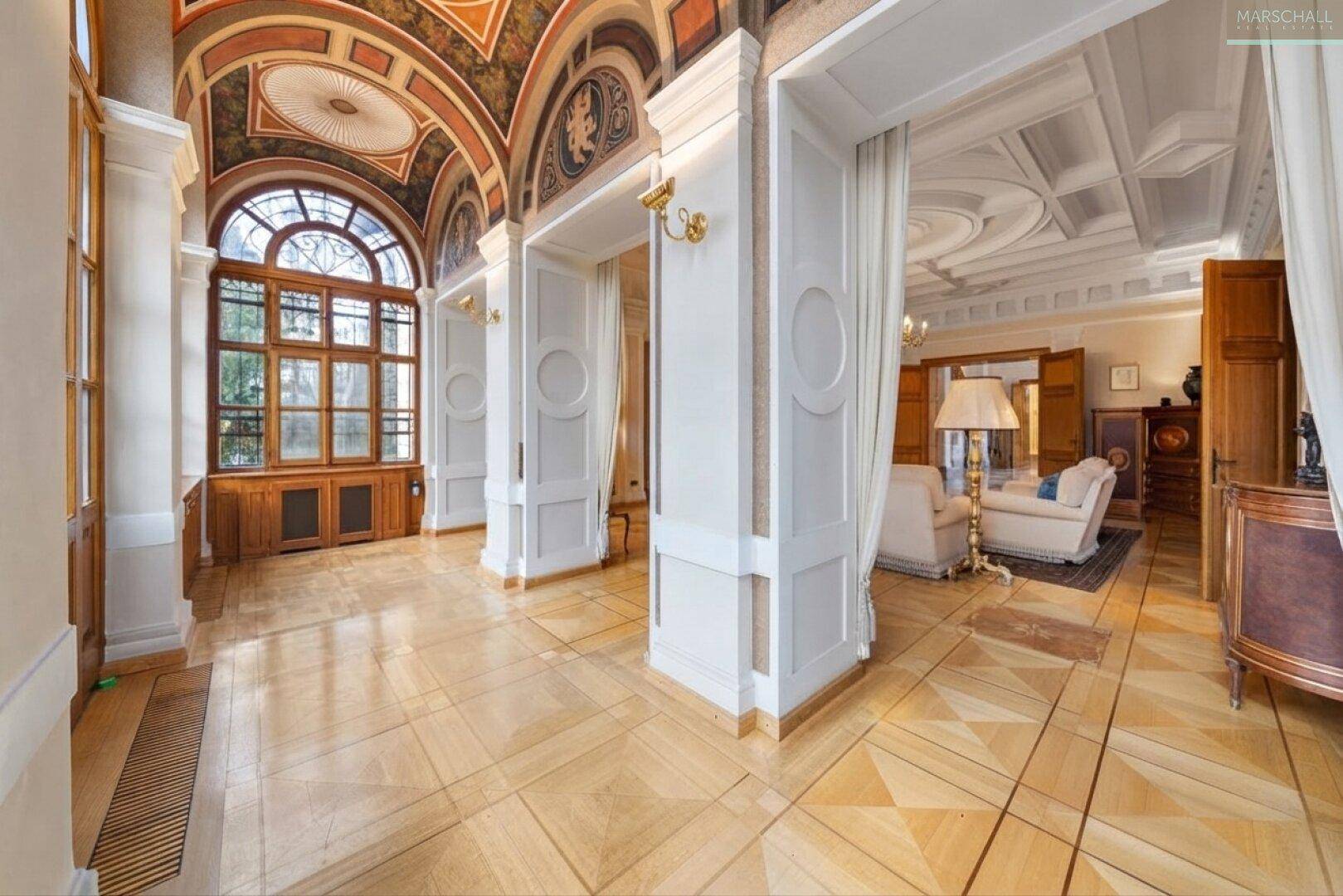 Prunkvoller Eingangsbereich mit kunstvoller Deckenmalerei, großen Fenstern und elegantem Parkettboden.