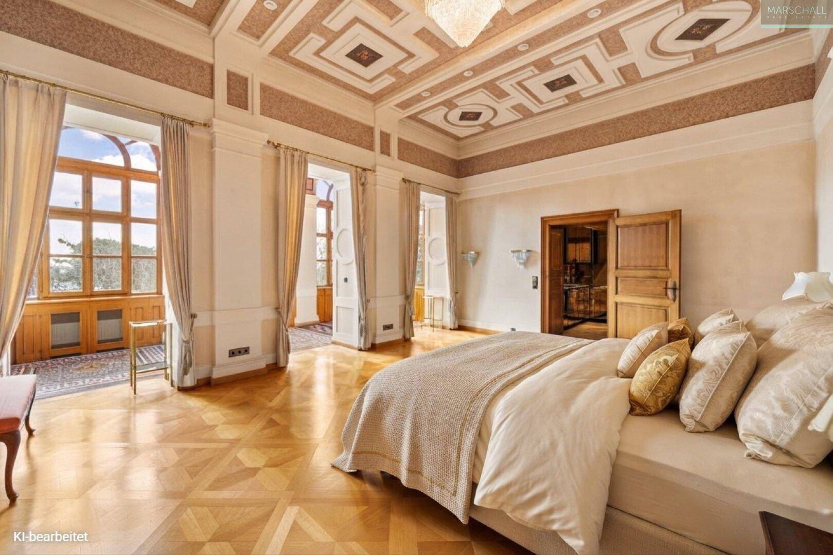 Geräumiges Schlafzimmer mit opulentem Deckenstuck, Parkettboden und Zugang zu einem hellen Wintergarten.