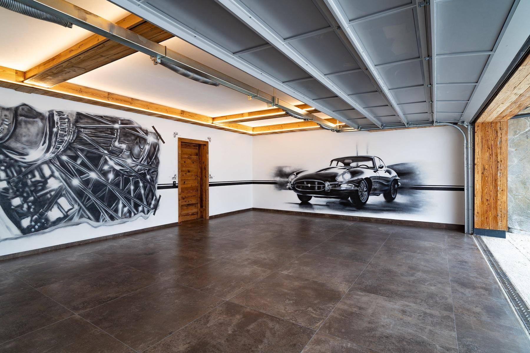 Geräumige Garage mit Fliesenboden und künstlerischer Wandgestaltung eines Oldtimers.