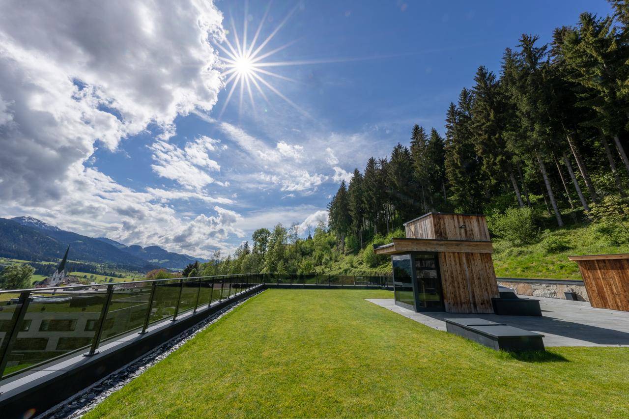 Grüne Dachfläche mit Rasen und Panoramablick auf die umliegende Berglandschaft.
