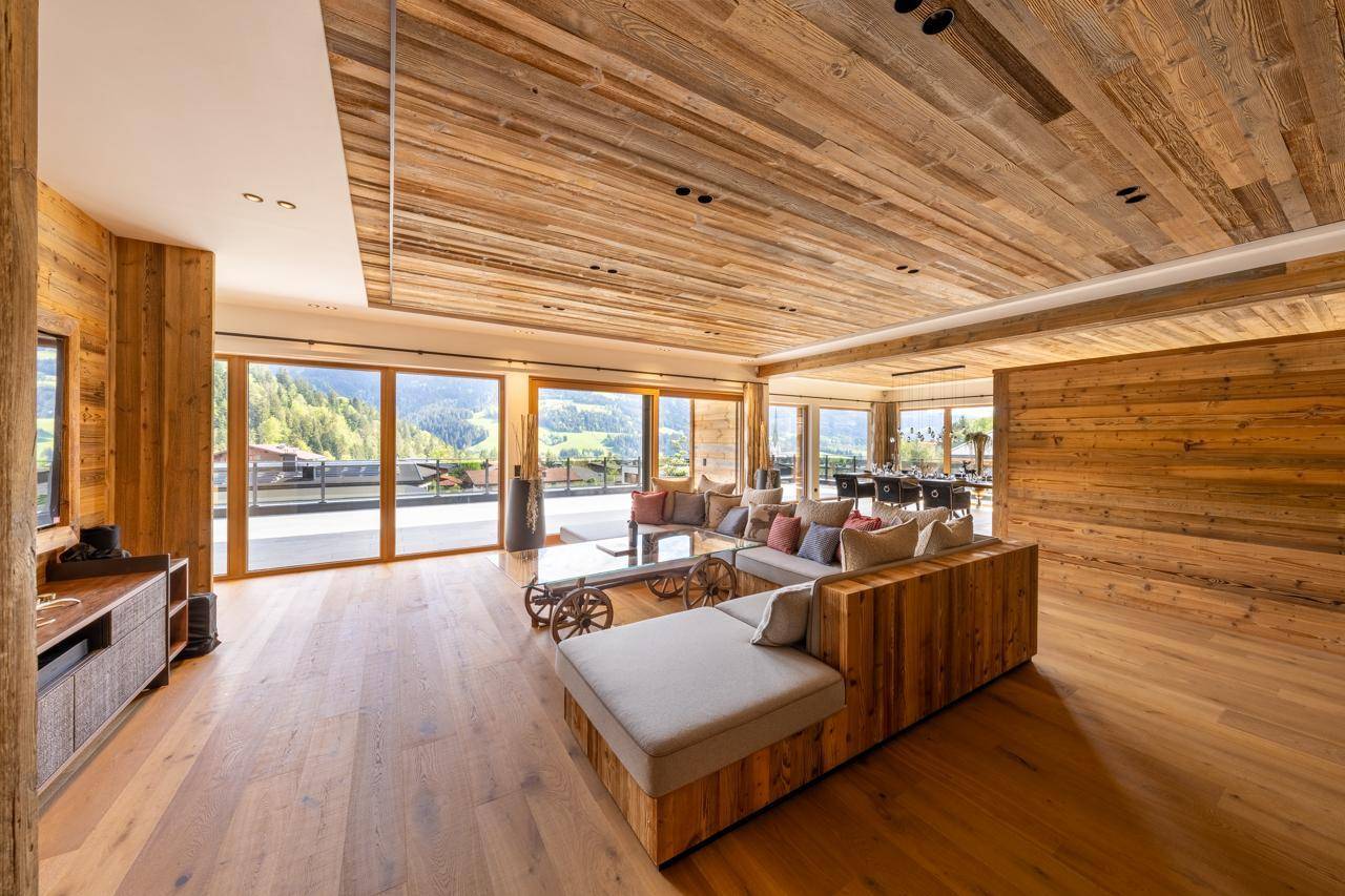 Geräumiges Wohnzimmer mit Holzboden, Holzwänden und gemütlicher Sitzecke.