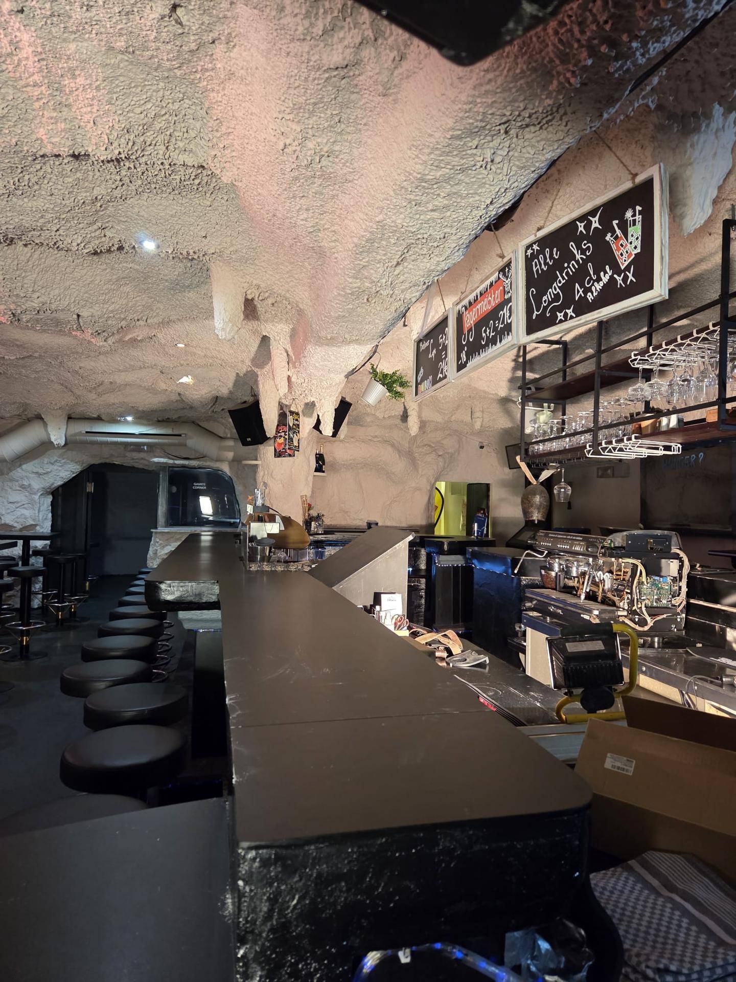 Thekenbereich einer Bar mit Höhlendecke, Getränkekarten und professioneller Ausstattung für den Ausschank.