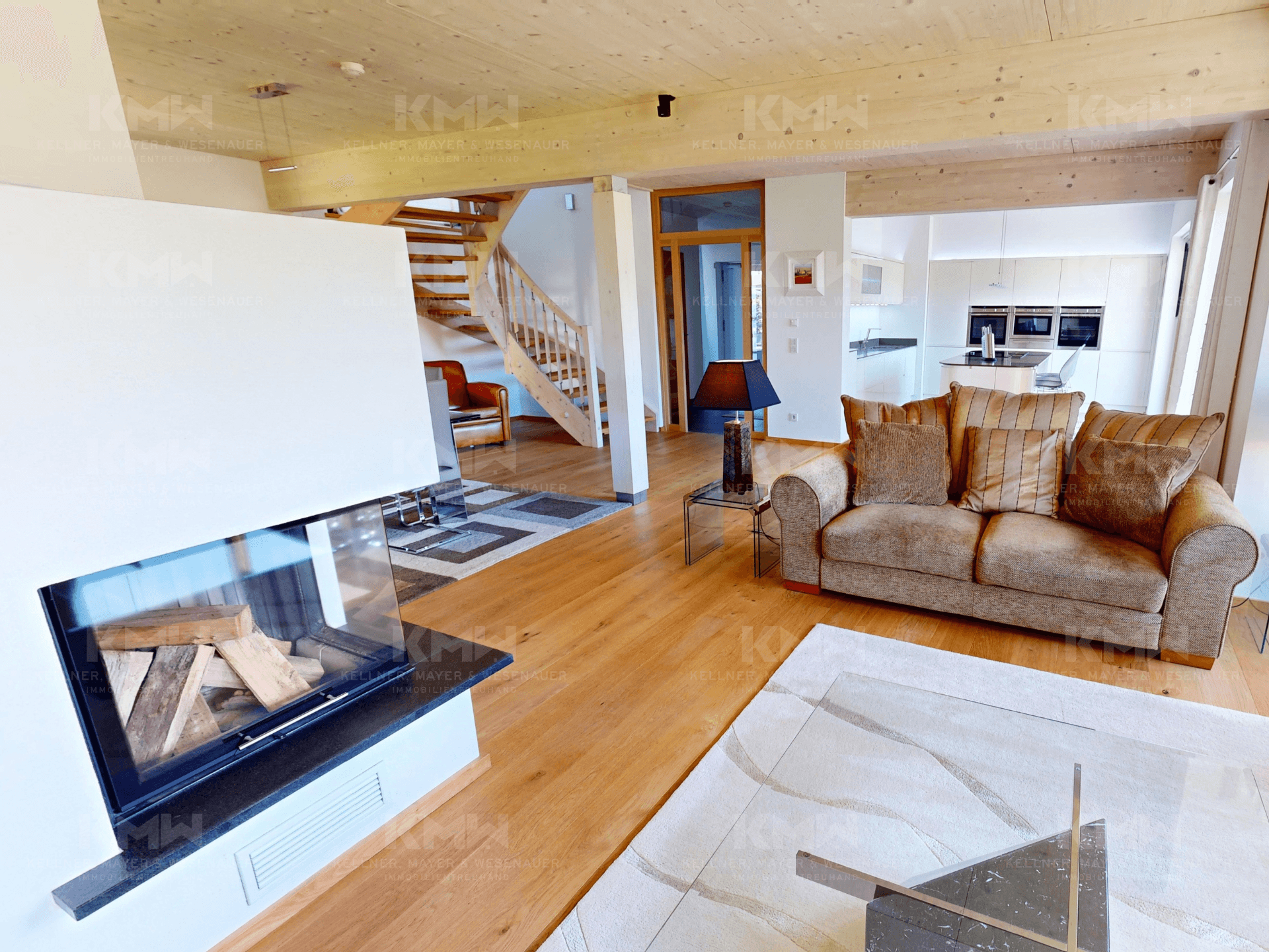 Helles Wohnzimmer mit modernem Kamin, Parkettboden und gemütlichen Sofas.