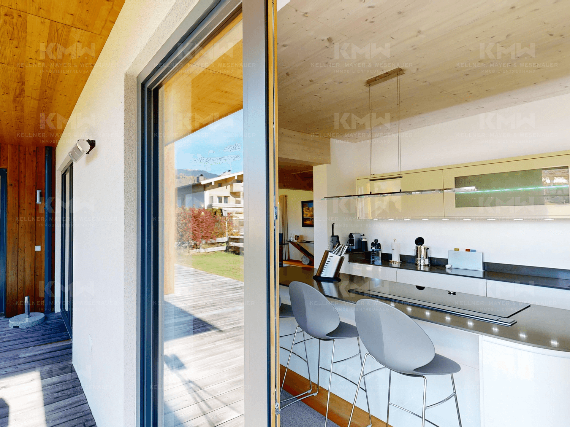 Helle Küche mit Zugang zur Terrasse und Blick auf den Außenbereich.