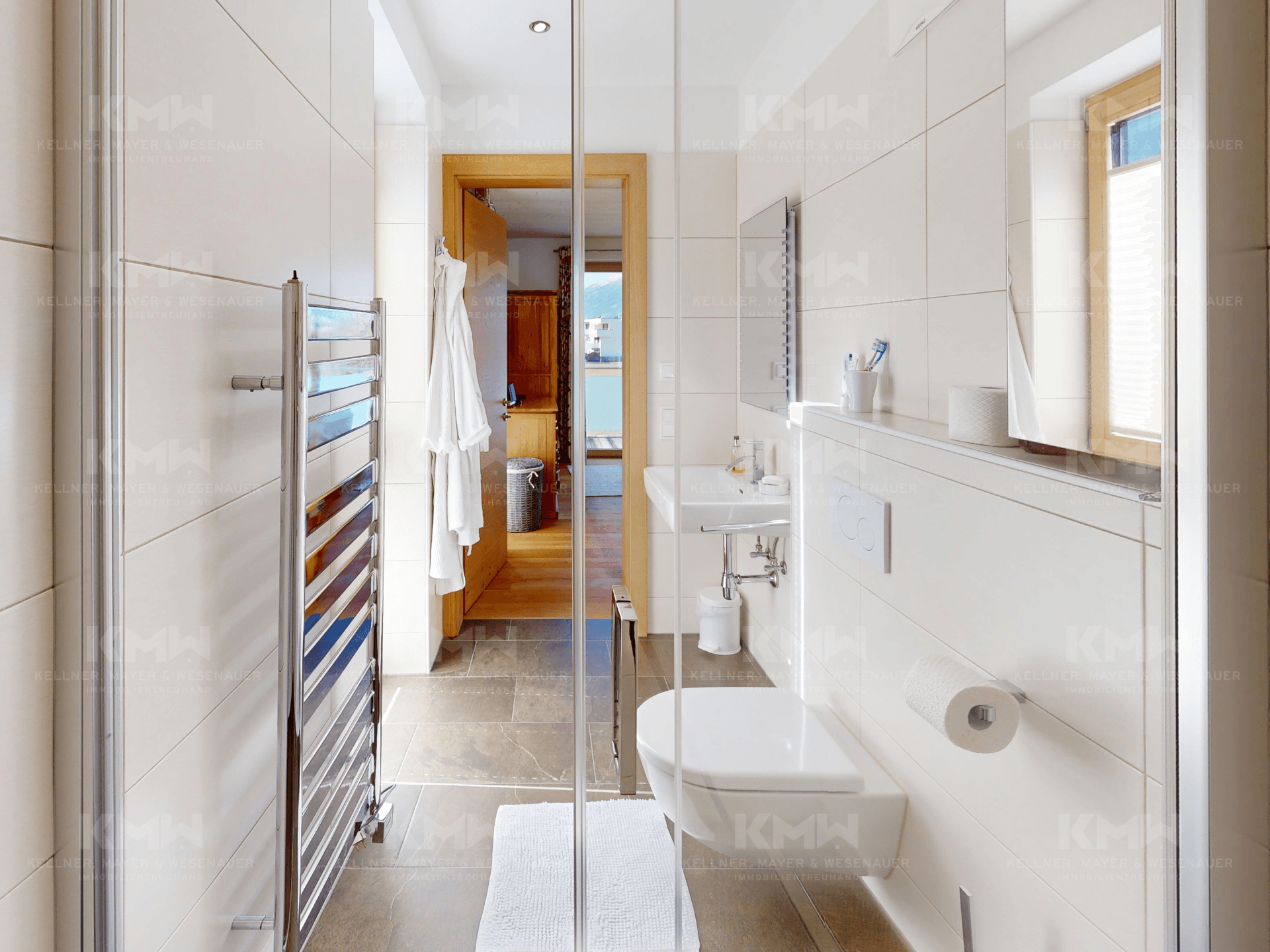 Modernes Badezimmer mit begehbarer Dusche, Wand-WC und beheiztem Handtuchhalter.