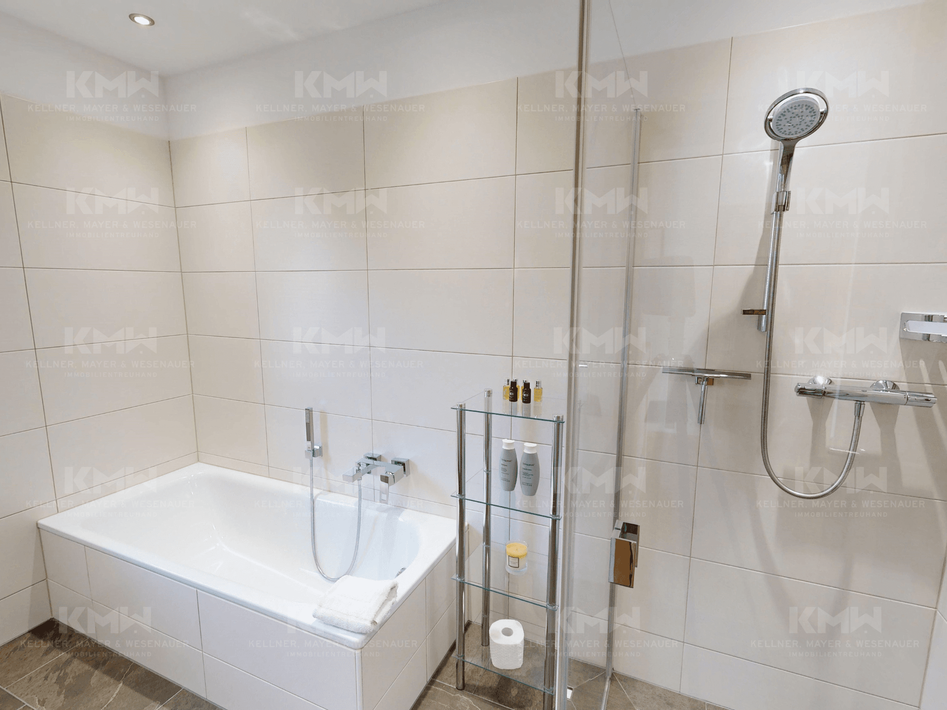 Modernes Badezimmer mit integrierter Badewanne und separater Dusche, hell gefliest.